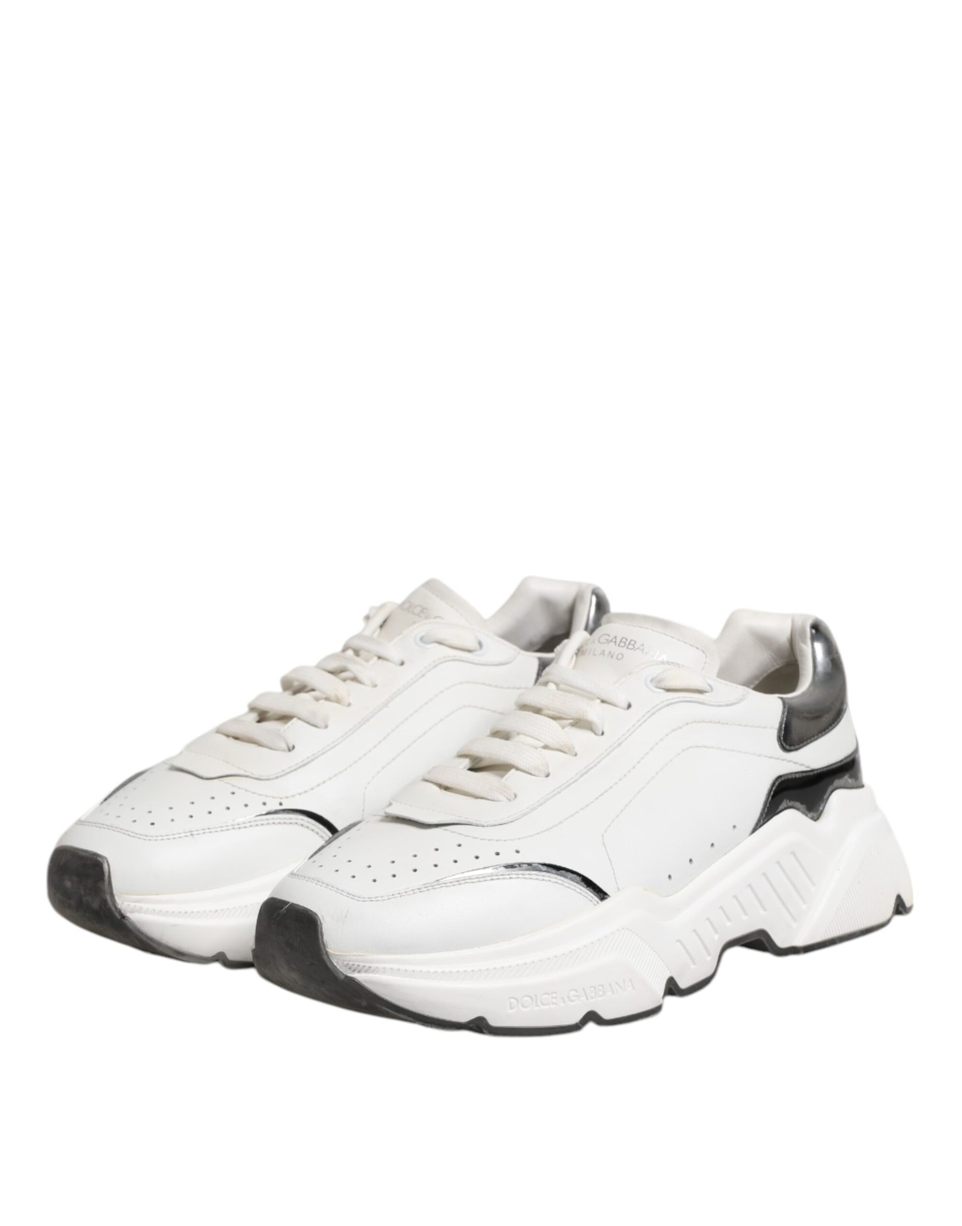White leather low top sneakers with black laces and soles, featuring a logo on the side