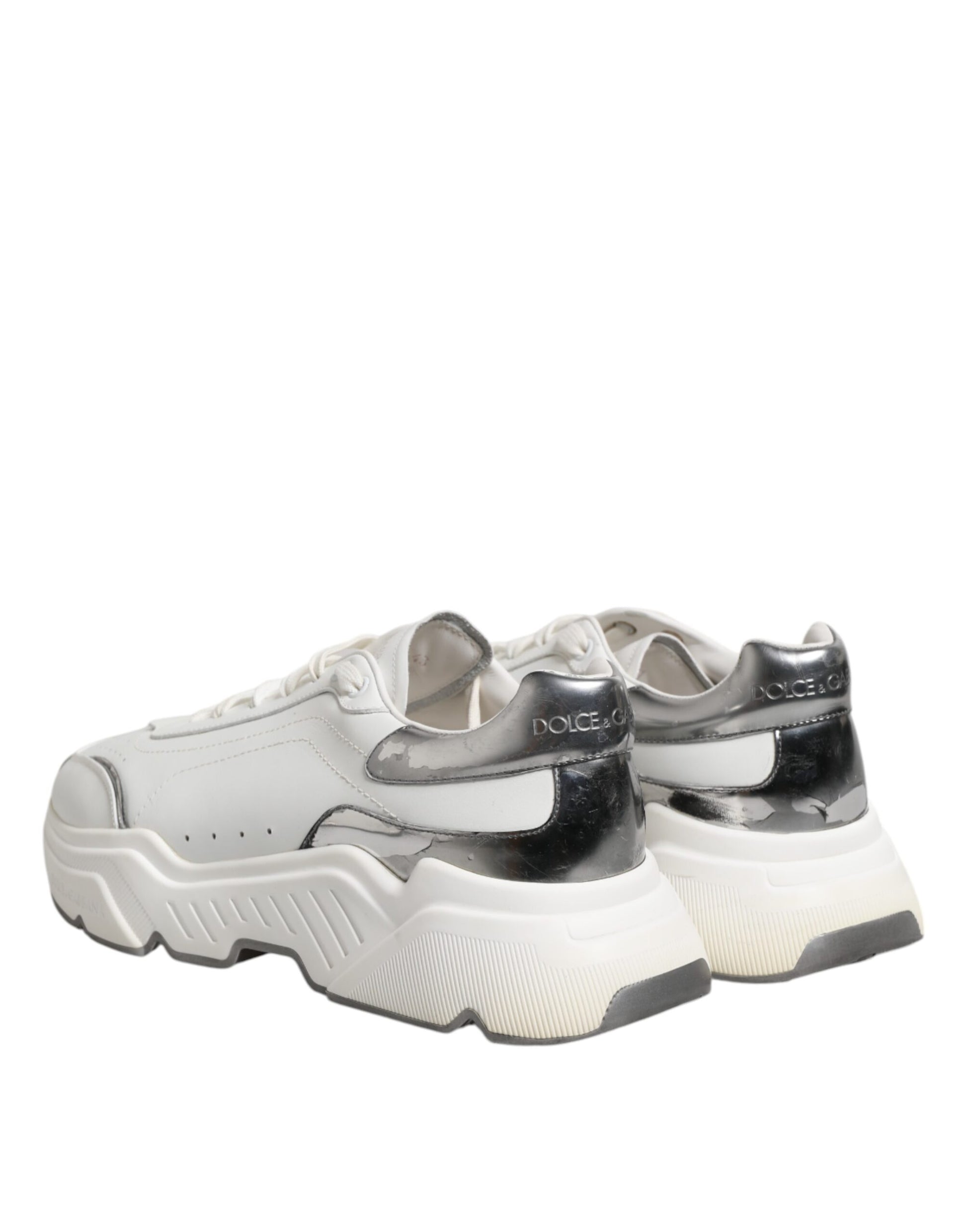 Pair of white leather sneakers with black laces and soles, featuring a low top design