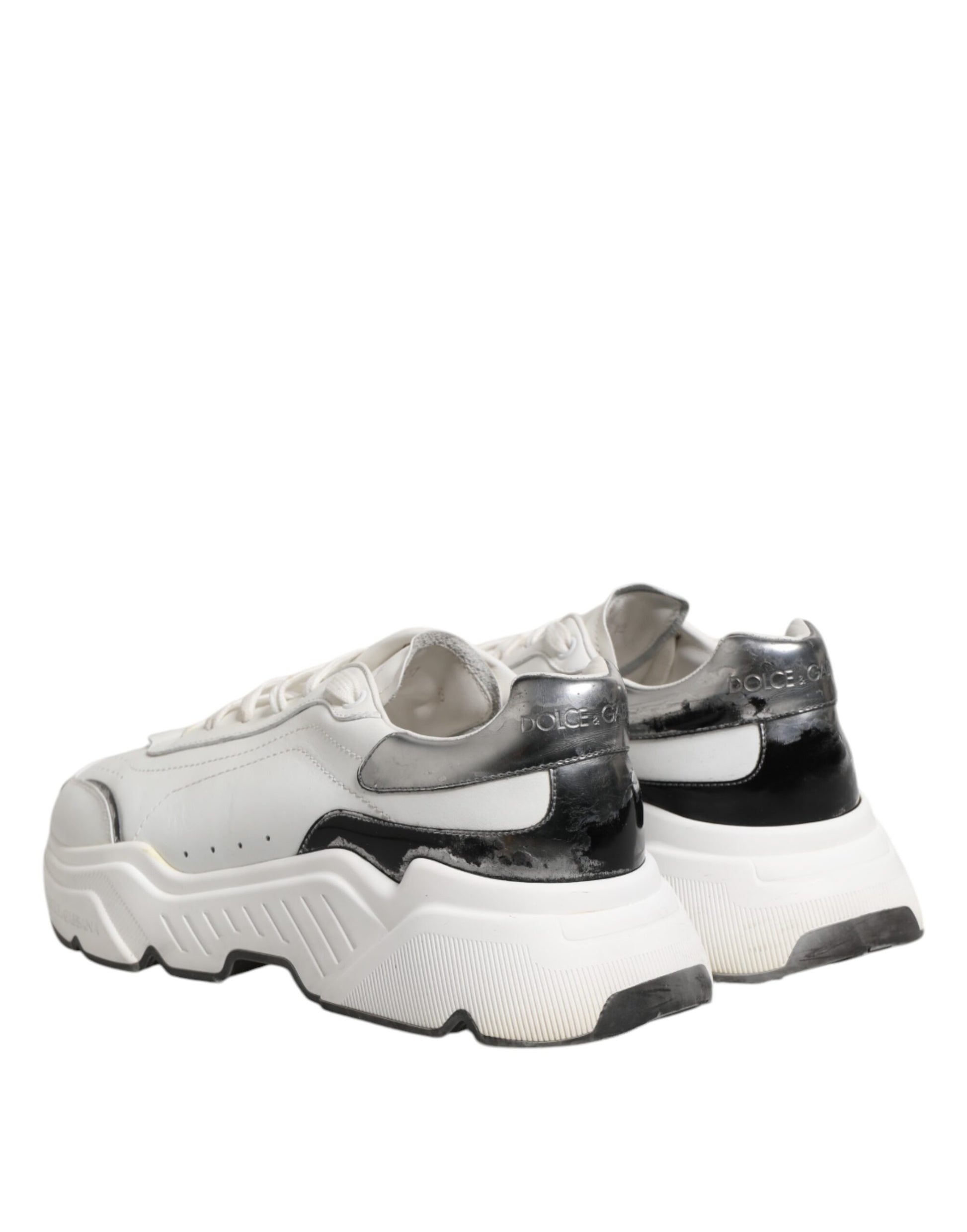 Pair of white and black leather sneakers with laces, featuring a low top design