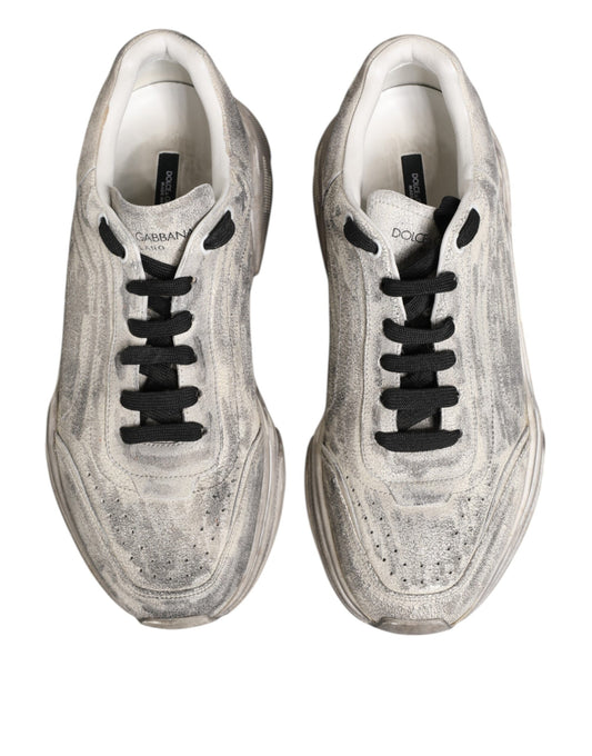 Pair of white sneakers with black laces, branded logo on side and tongue