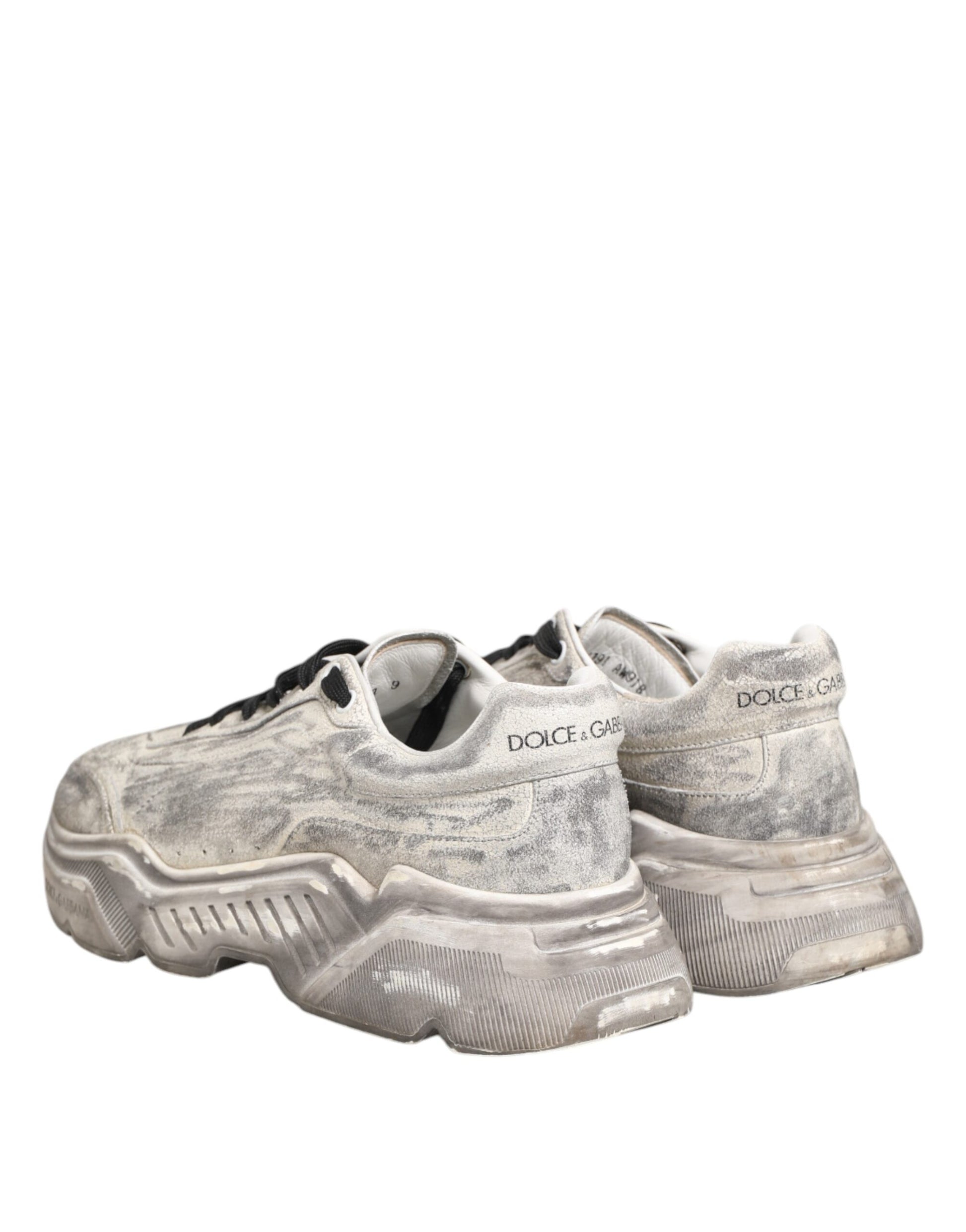 A pair of white sneakers with black laces, featuring a low top design and the brand name "Dolce & Gabbana" on the side