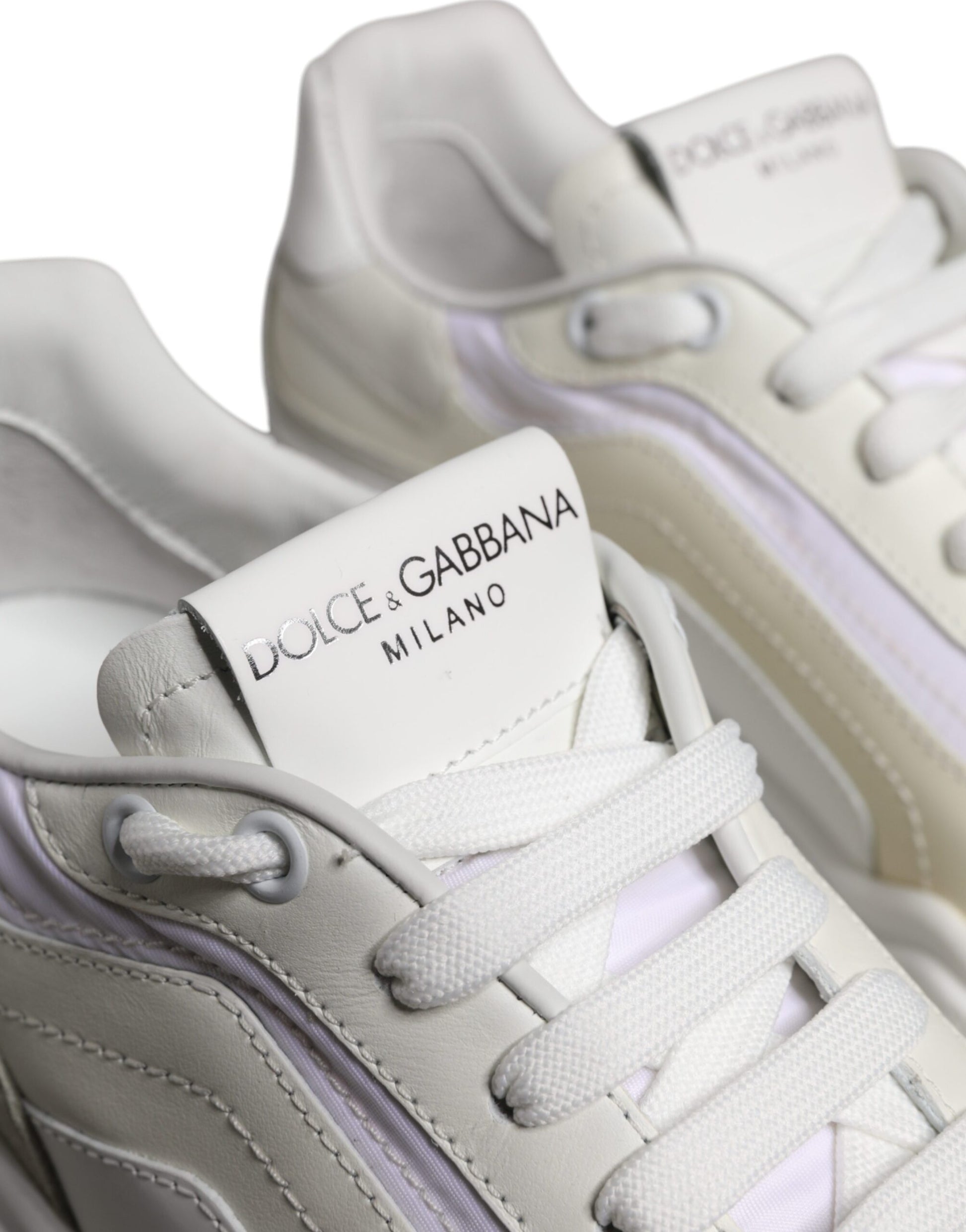 Pair of white sneakers with pink accents, featuring brand logo on tongue and side