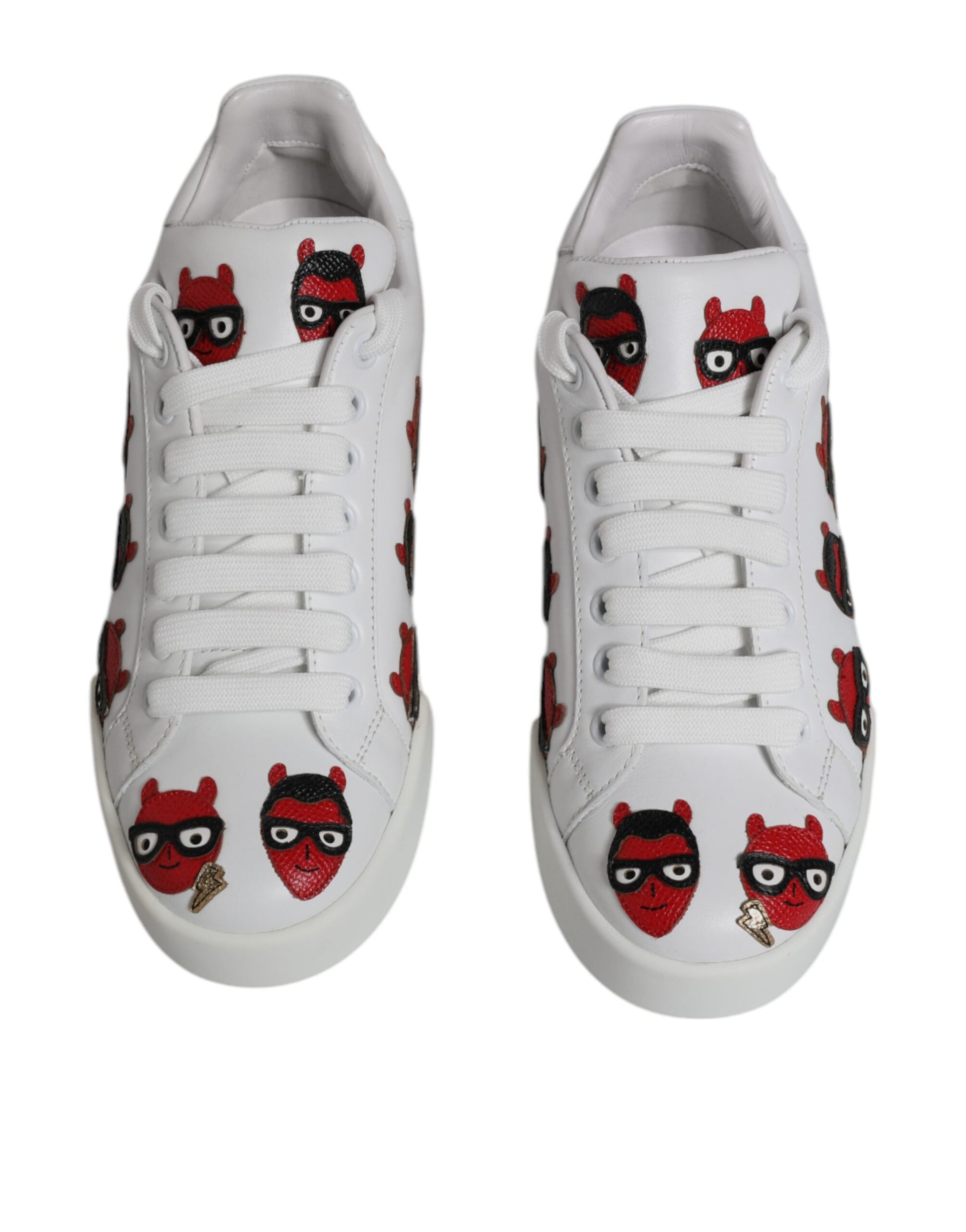 Pair of white sneakers with red devil designs on side