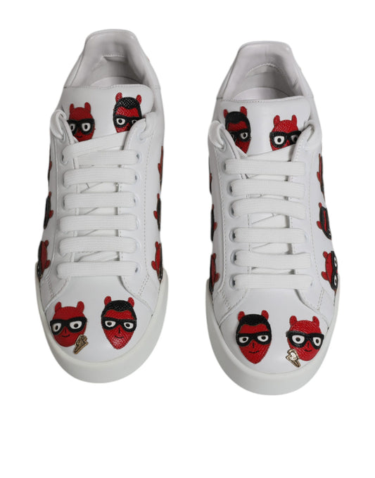 Pair of white sneakers with red devil designs on side