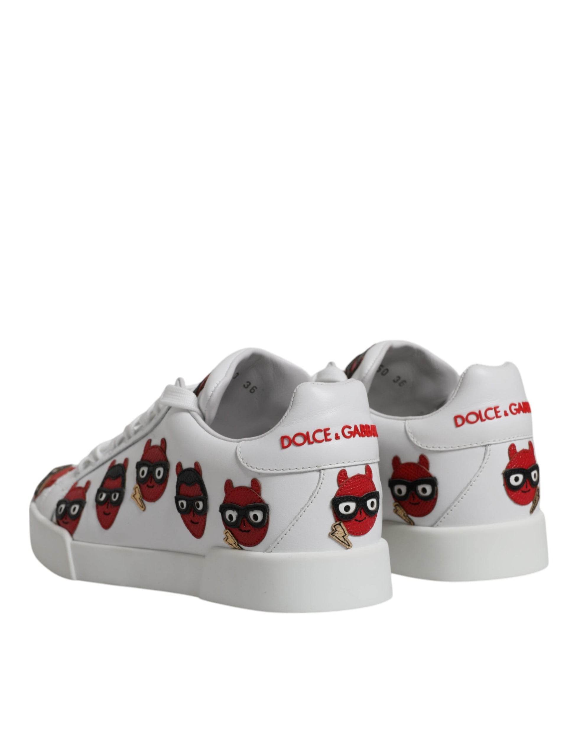 Pair of white sneakers with red devil faces on side and D&G logo on tongue