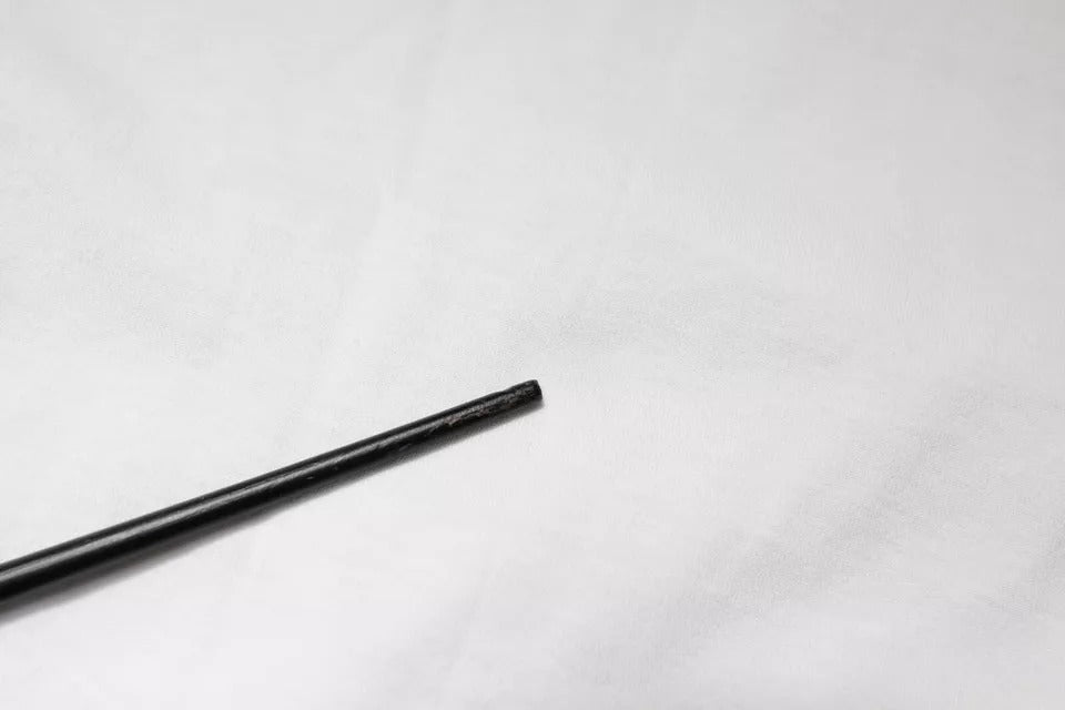 Long metal rod on white surface