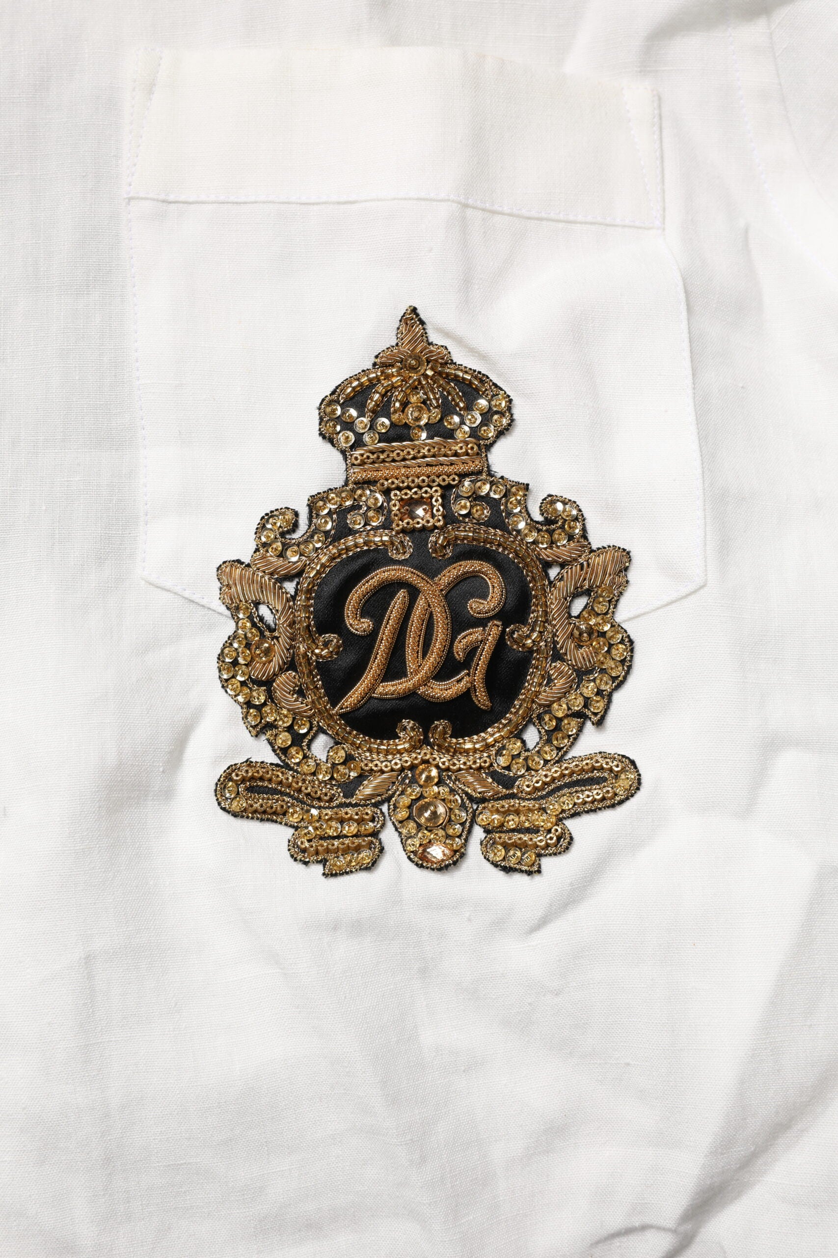 Gold embroidered crown on white shirt