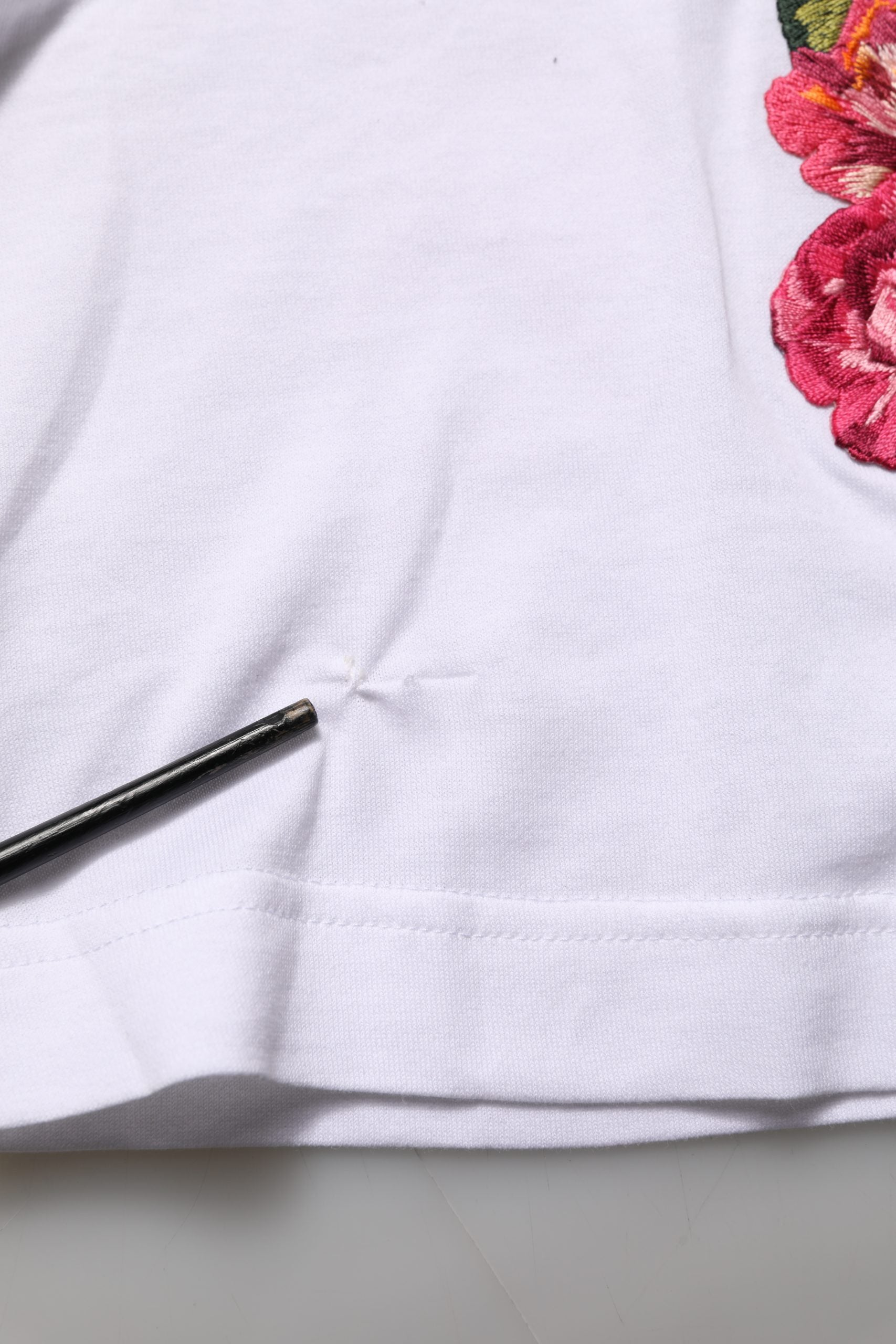 A white cotton jersey crop t-shirt with a floral pattern on the sleeve