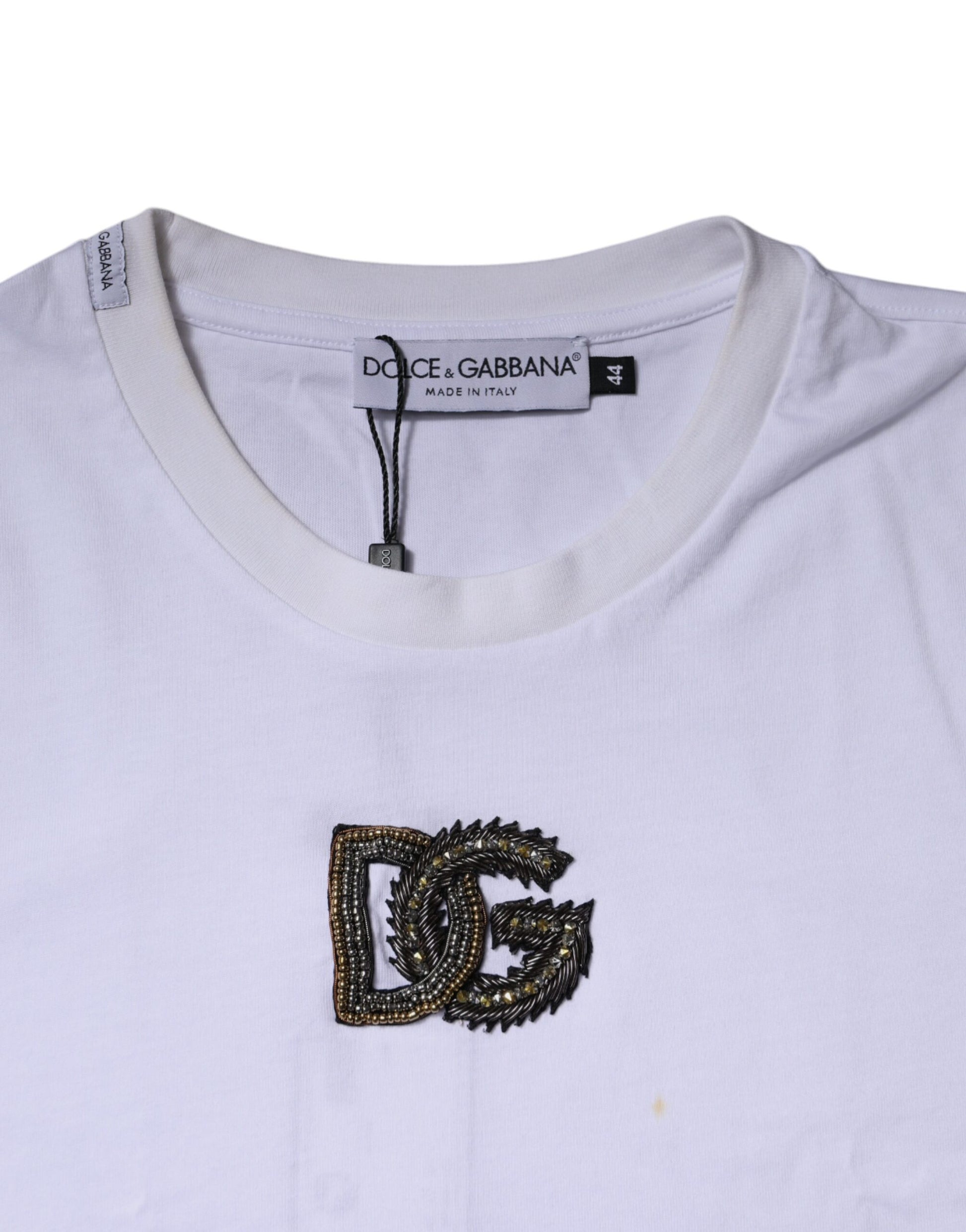 White t-shirt with a gold embroidered logo on front