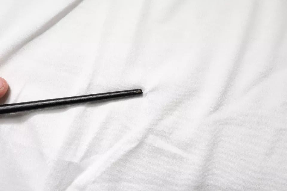 Black eyeliner pencil on white surface