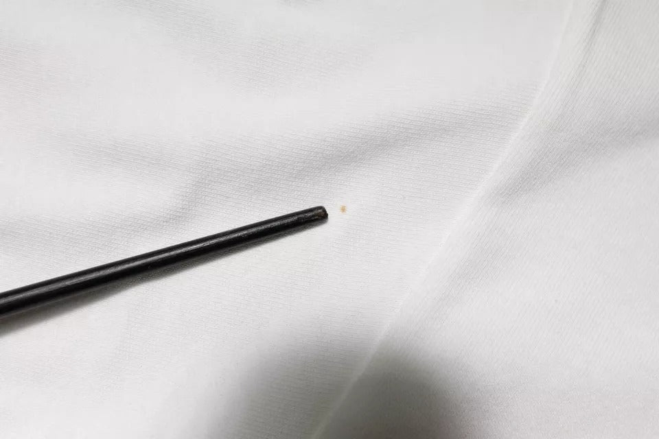 Black metal object on white fabric