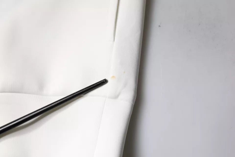 Black metal sewing needles on white fabric