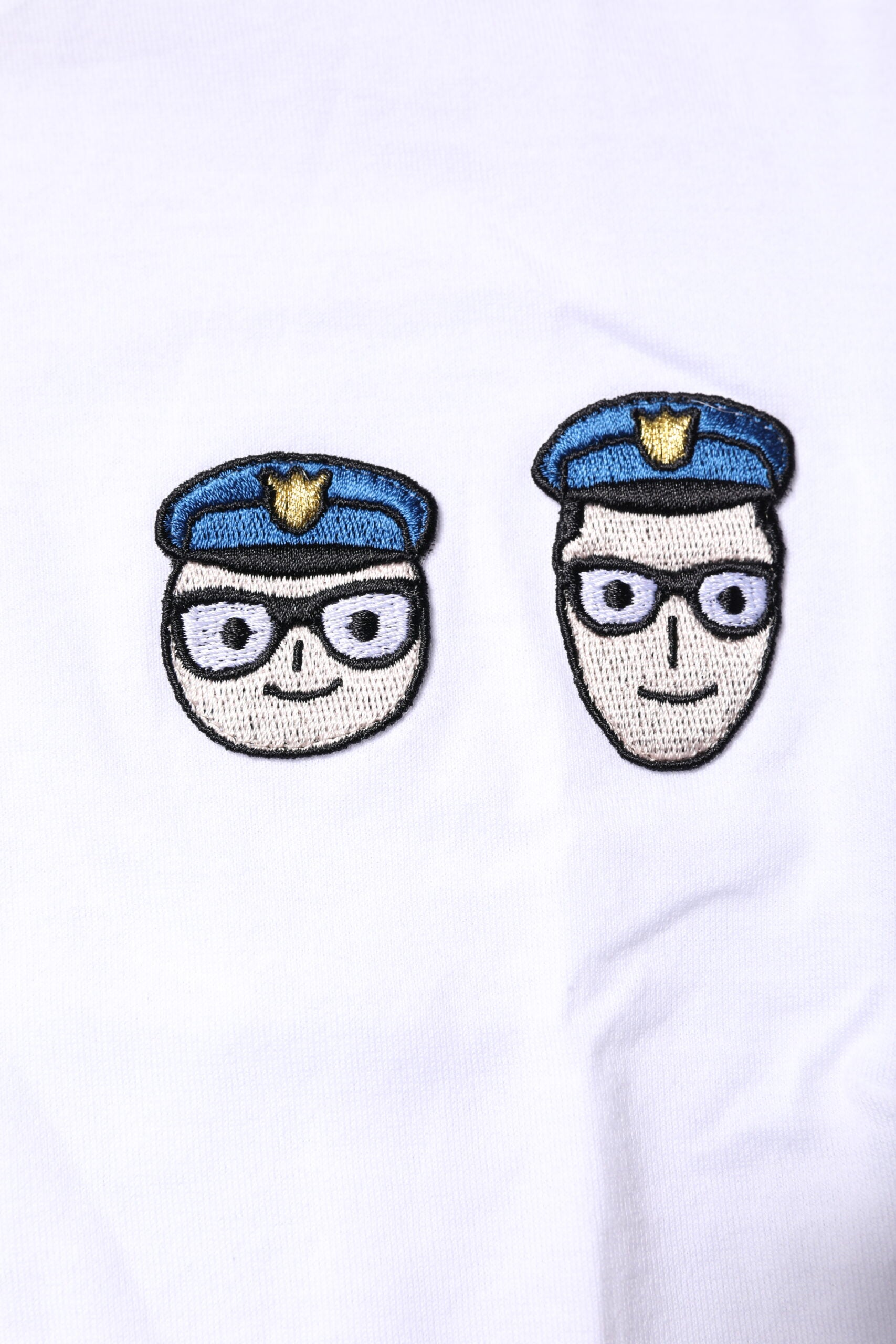 Embroidered cartoon police officers on a white fabric background