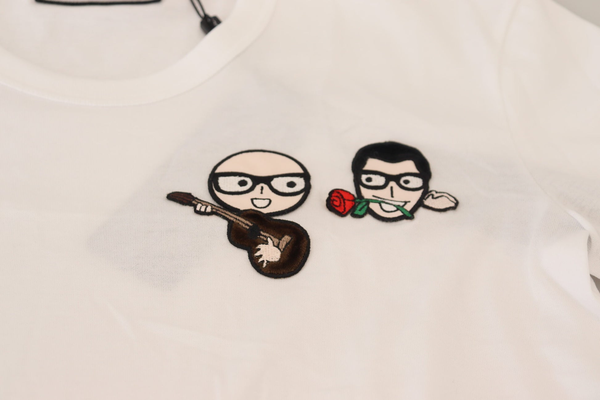 White t-shirt with embroidered cartoon characters playing guitar and holding roses