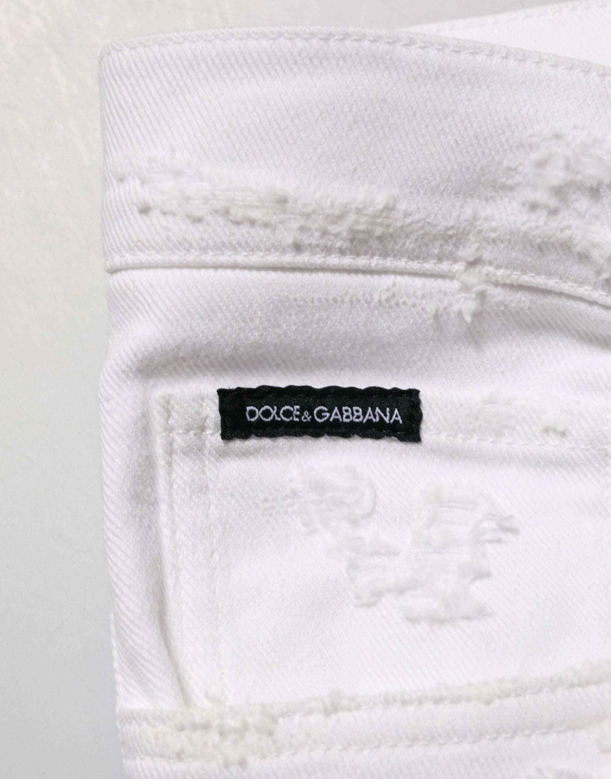White jeans with a black label on the waistband