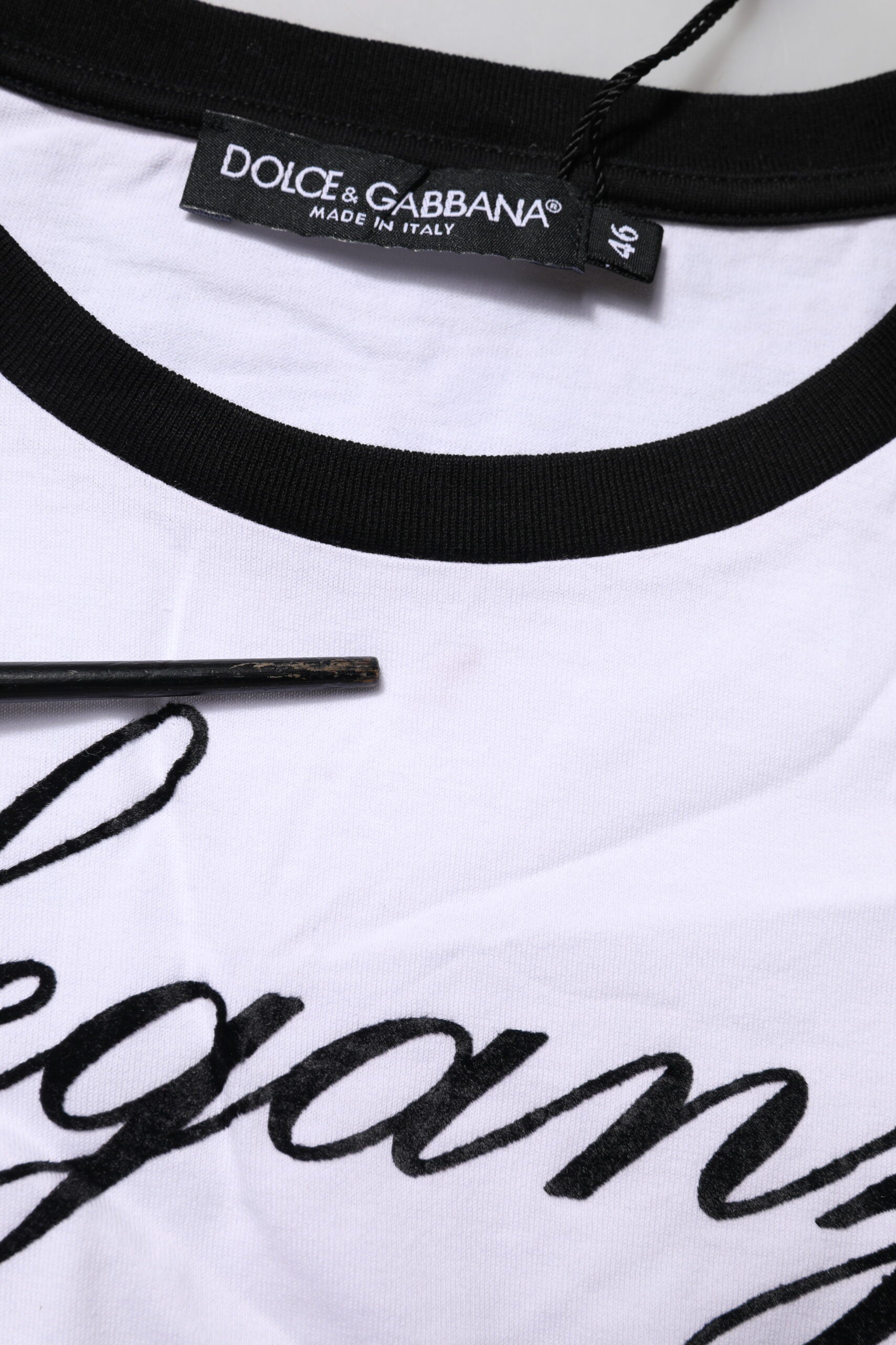 White t-shirt with black lettering and a black collar