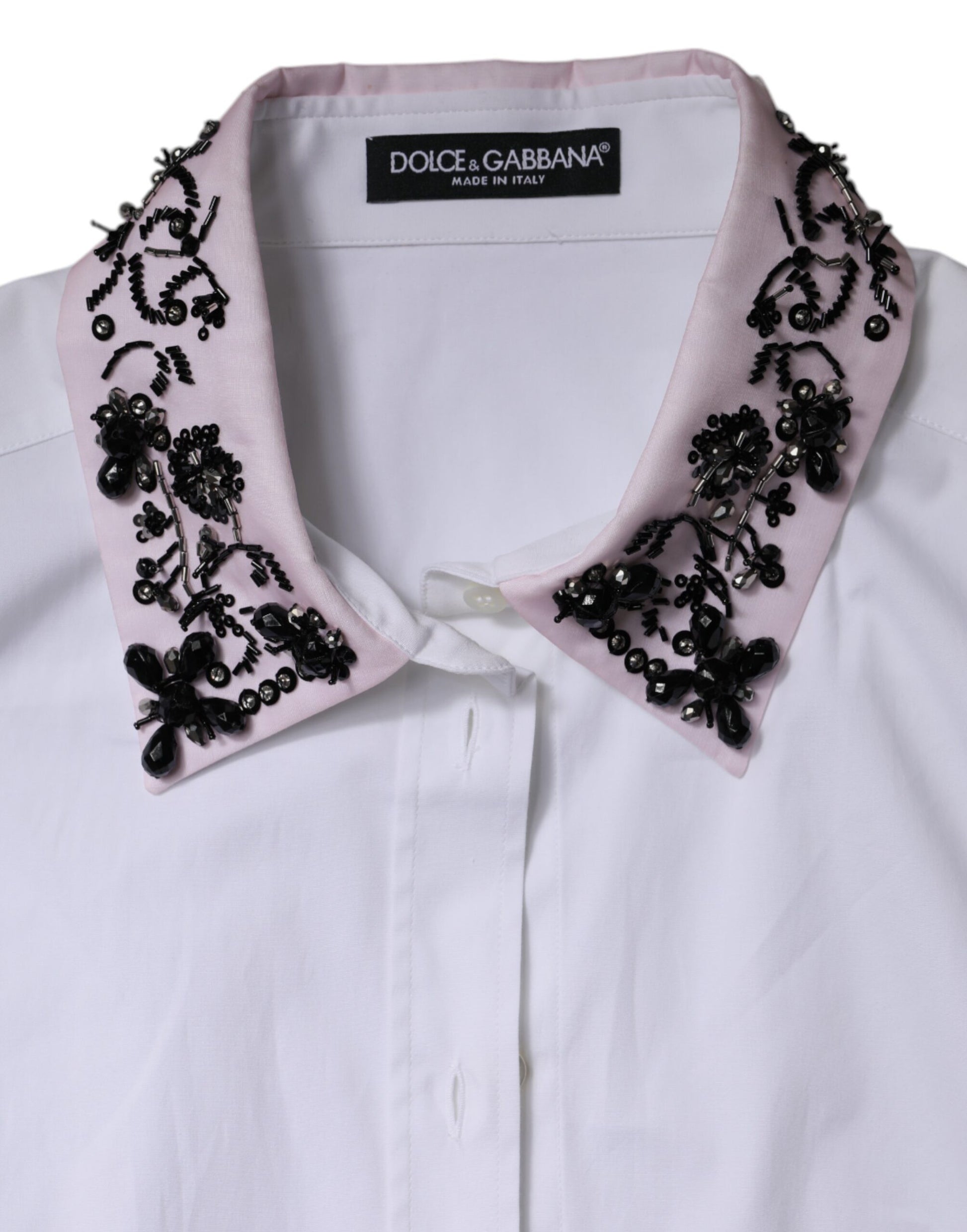 A white collared dress shirt with pink and black embellishments on the neckline