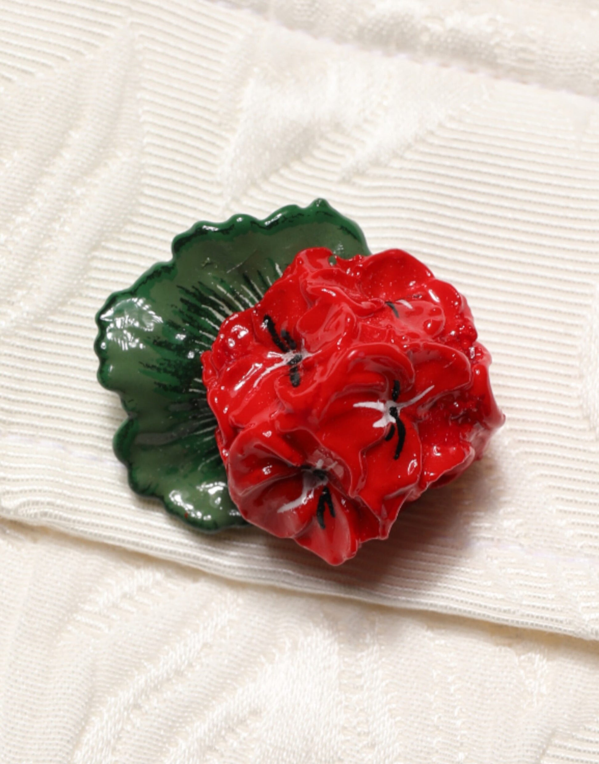 Red poppy flower brooch on fabric background