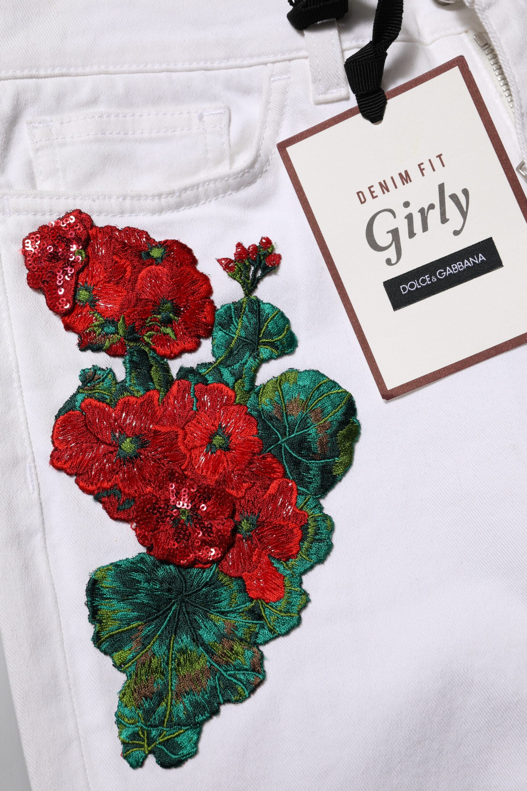 White jeans with red floral embroidery on front
