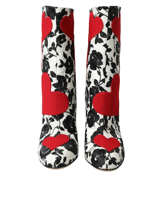 Pair of knee high boots with a floral pattern and red accents