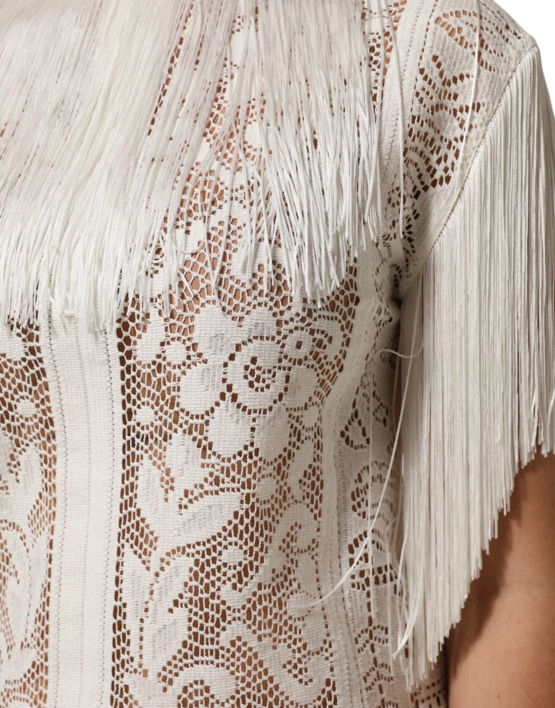 A white lace dress with fringed sleeves and a floral pattern