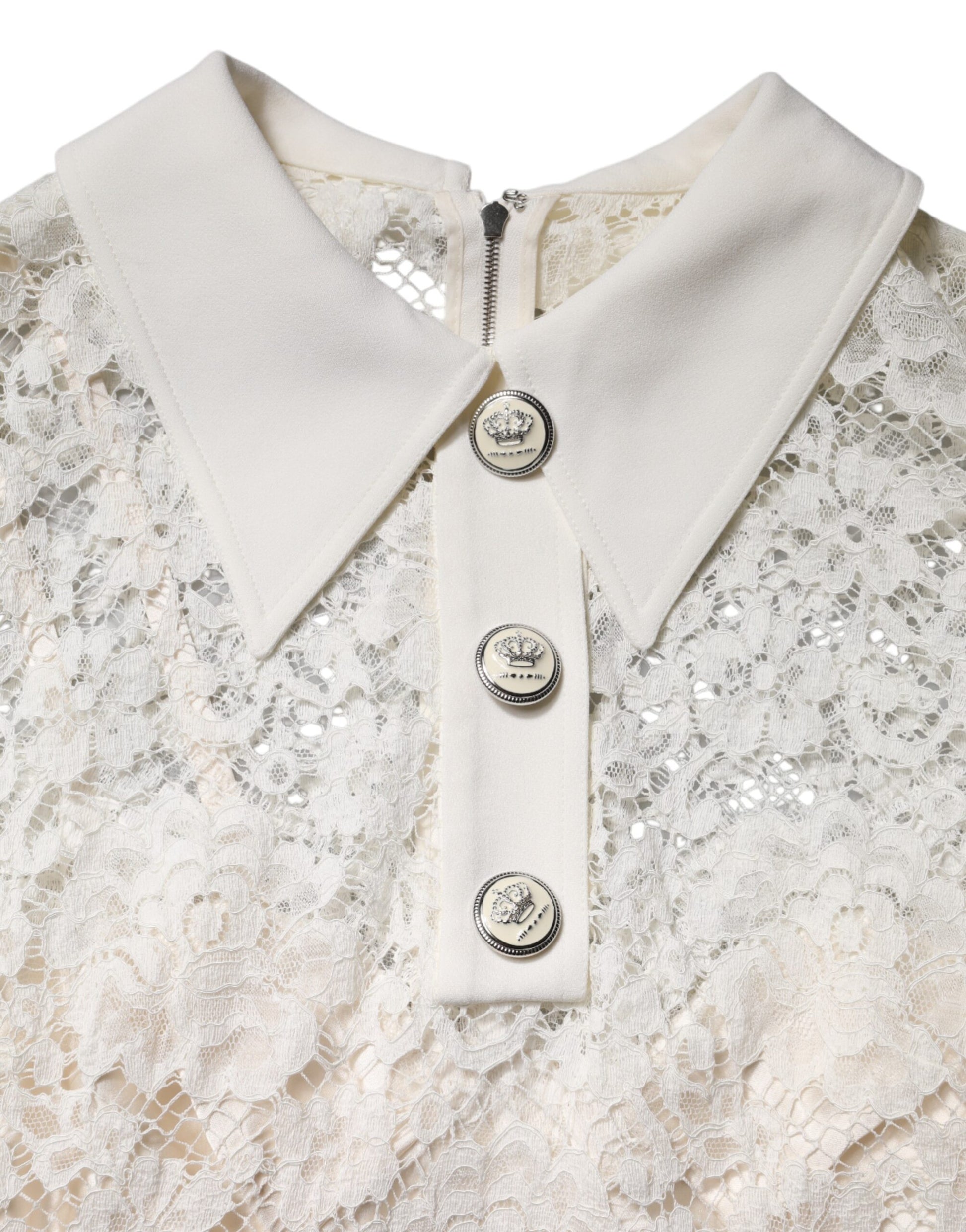 A white lace dress with long sleeves and a high neckline. It features a floral pattern and is designed by Dol