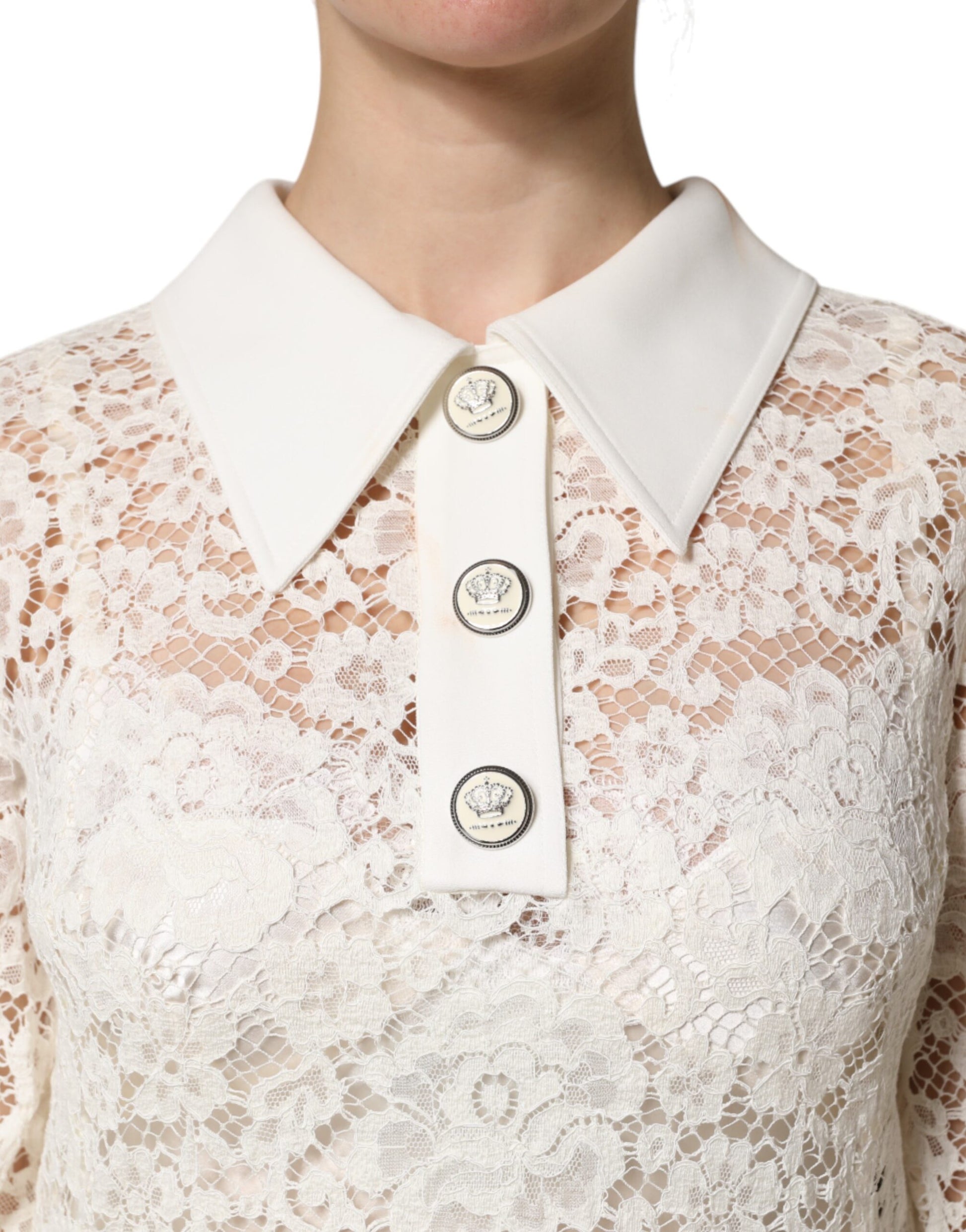 A white lace dress with long sleeves and a collar, featuring floral patterns