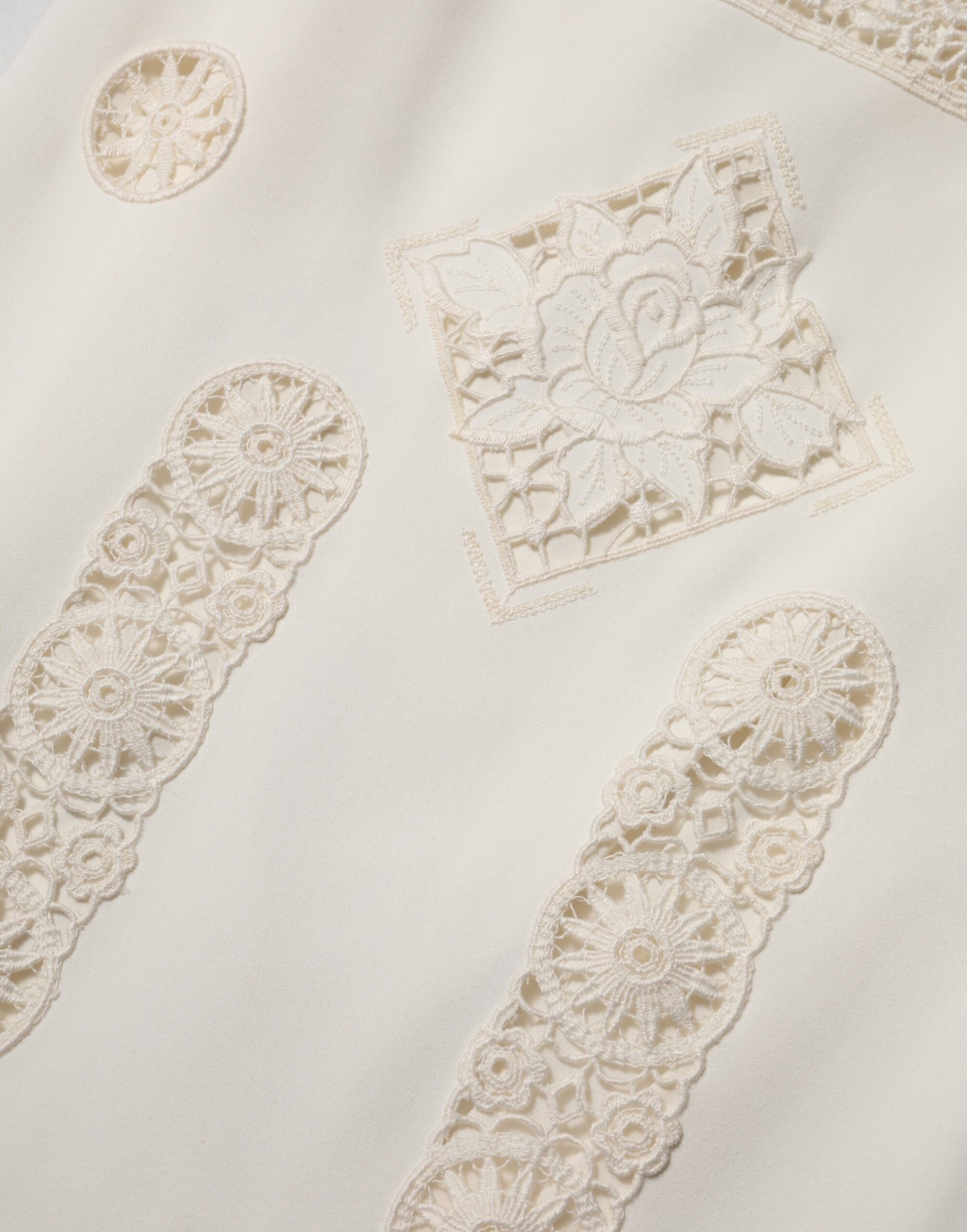 A white lace midi dress with floral embroidery on the bodice