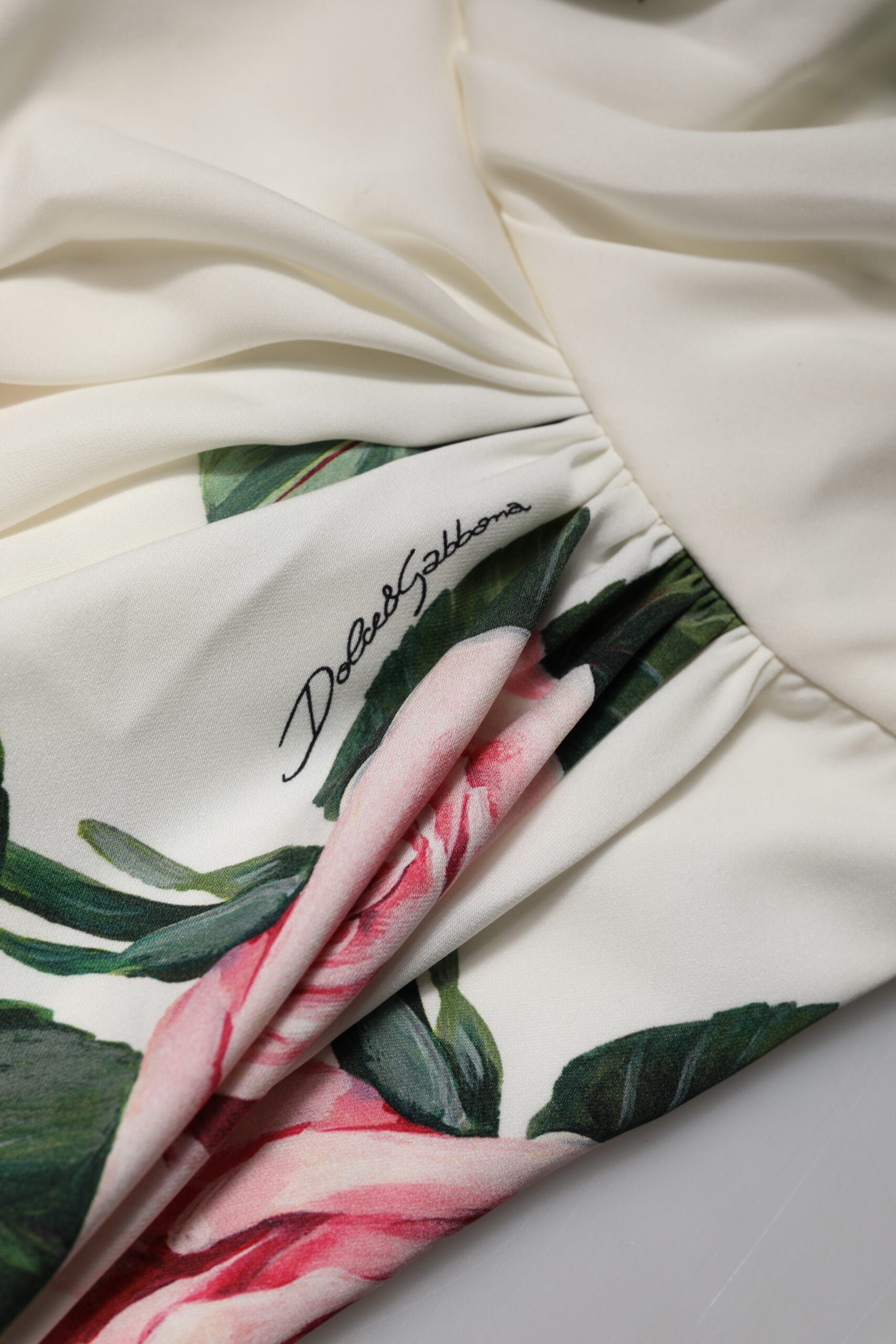 A white floral midi dress with a one shoulder design, featuring a pink flower pattern