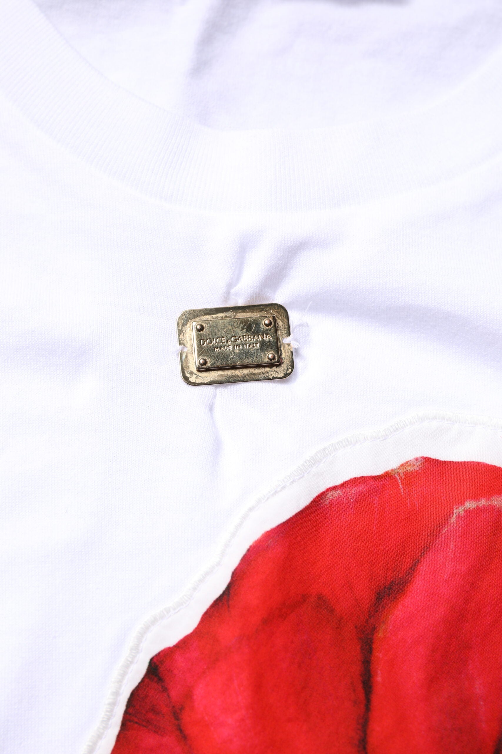 White t-shirt with a red flower design on front