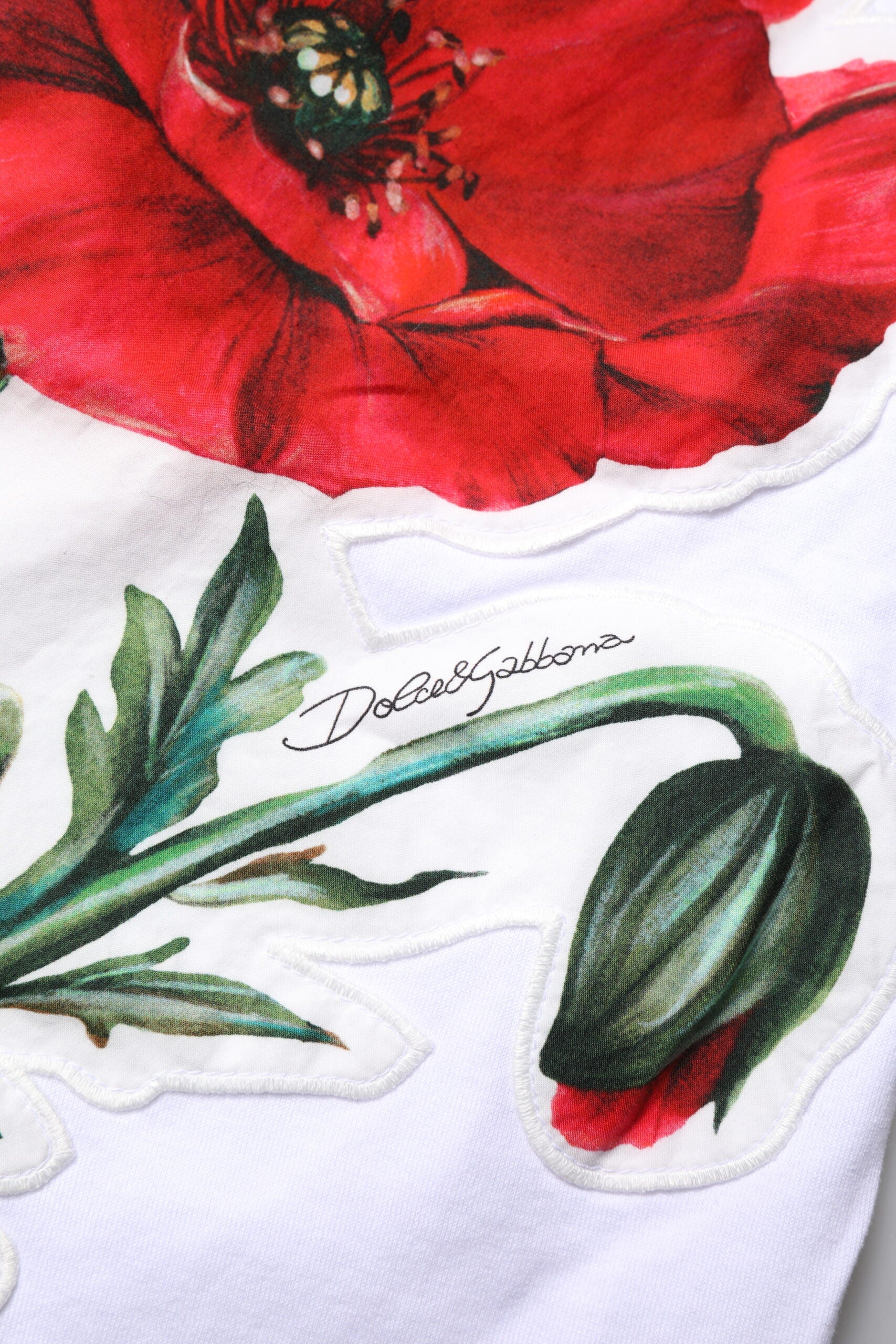 Red flower embroidered on white fabric