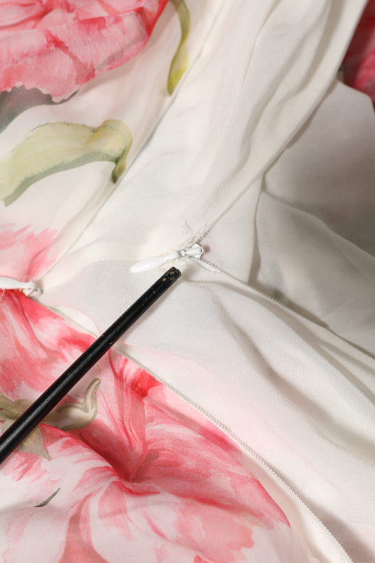 A close-up of a white floral silk halter dress with a maxi length
