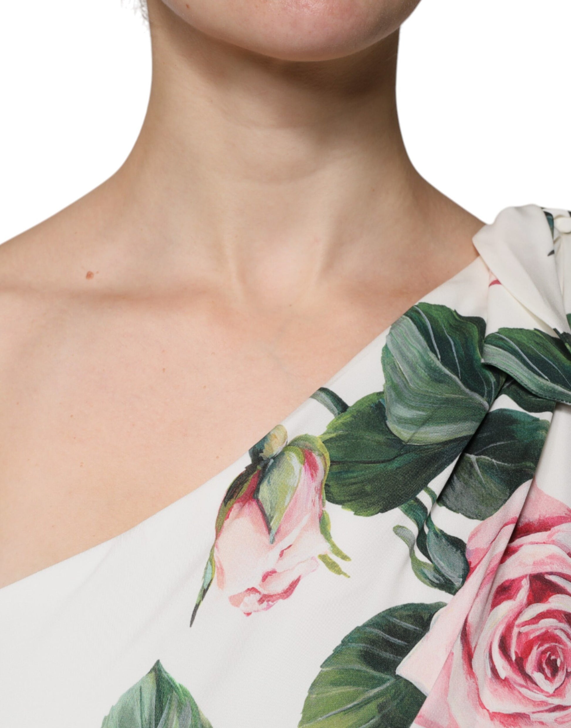 A woman wearing a white floral silk one shoulder midi dress with pink roses