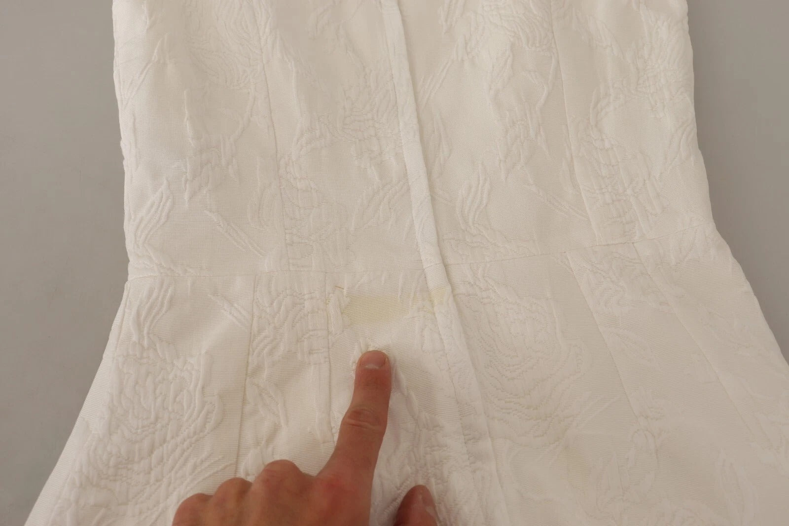 A white floral sleeveless sheath mini dress with a visible stain