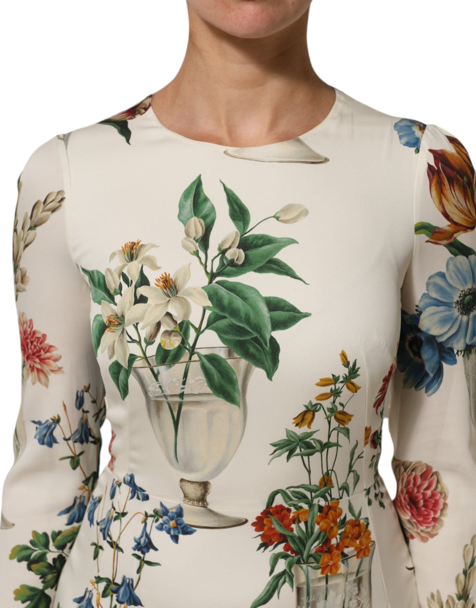 A white midi dress with a floral print design, featuring a vase of flowers on the front
