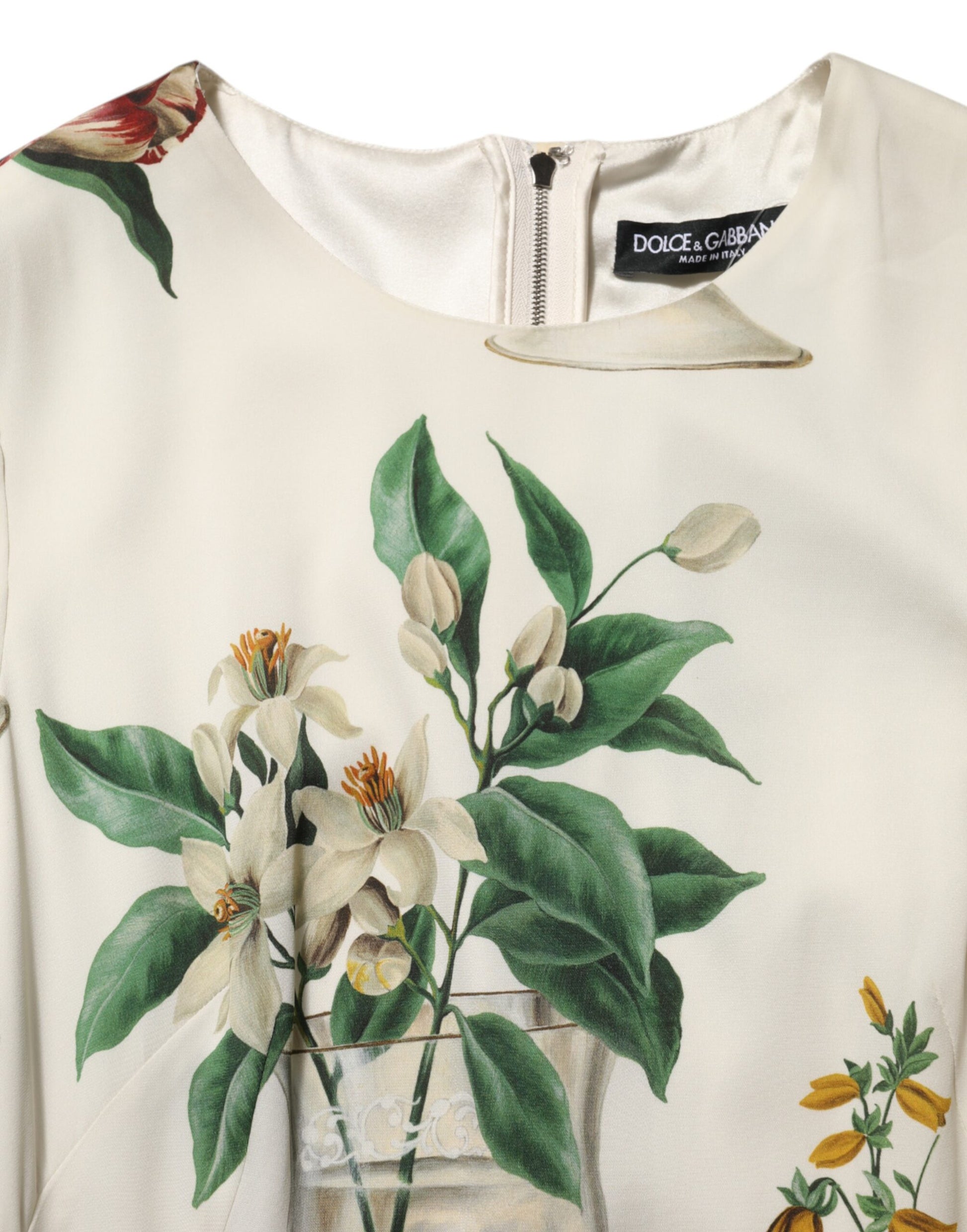A white midi dress with a floral print featuring leaves and flowers, designed by Dolce & Gabbana