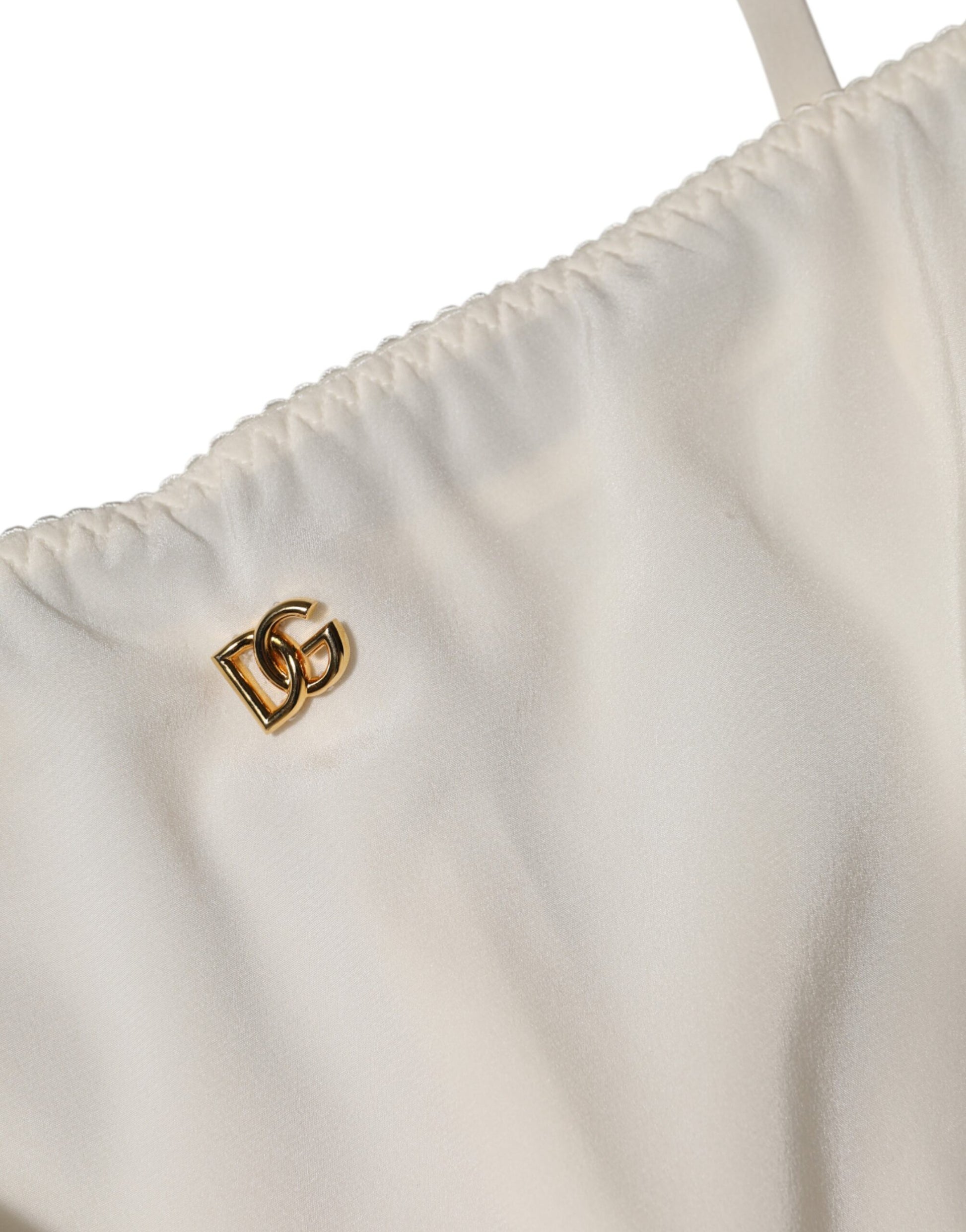 A white full slip dress with a gold D&G logo on the front