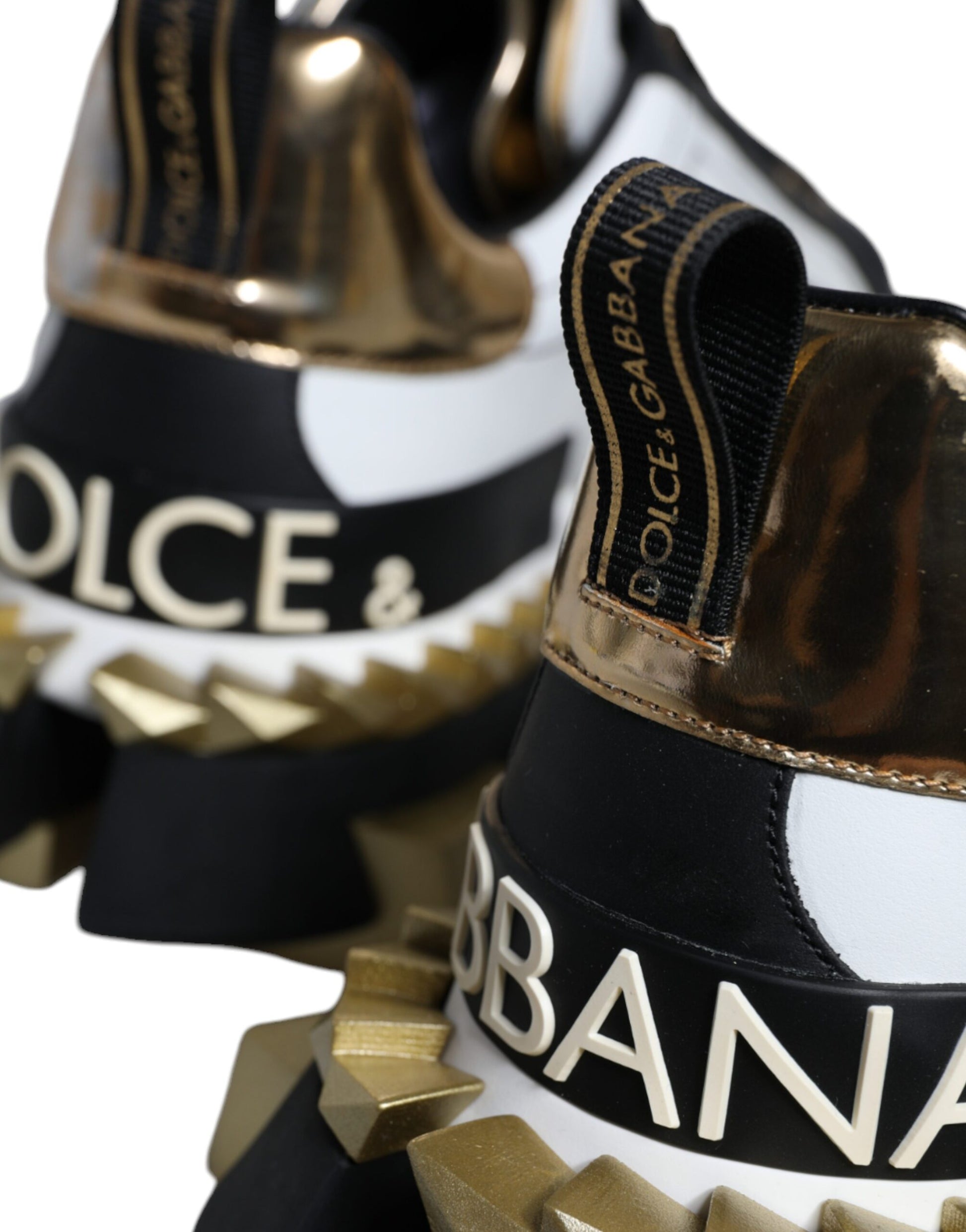 Black and white sneakers with gold accents featuring brand names
