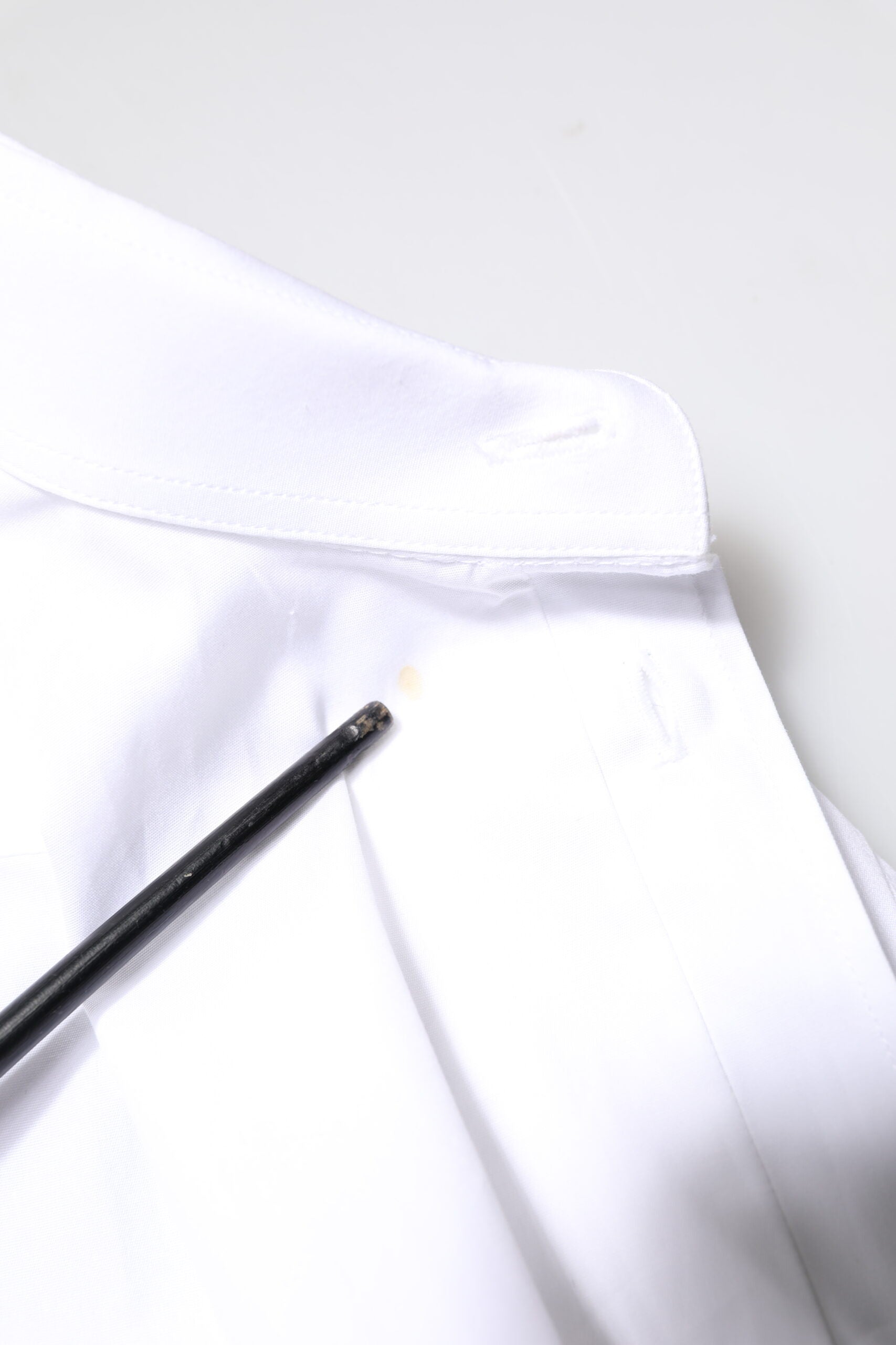 A white cotton dress shirt with long sleeves, featuring a gold design
