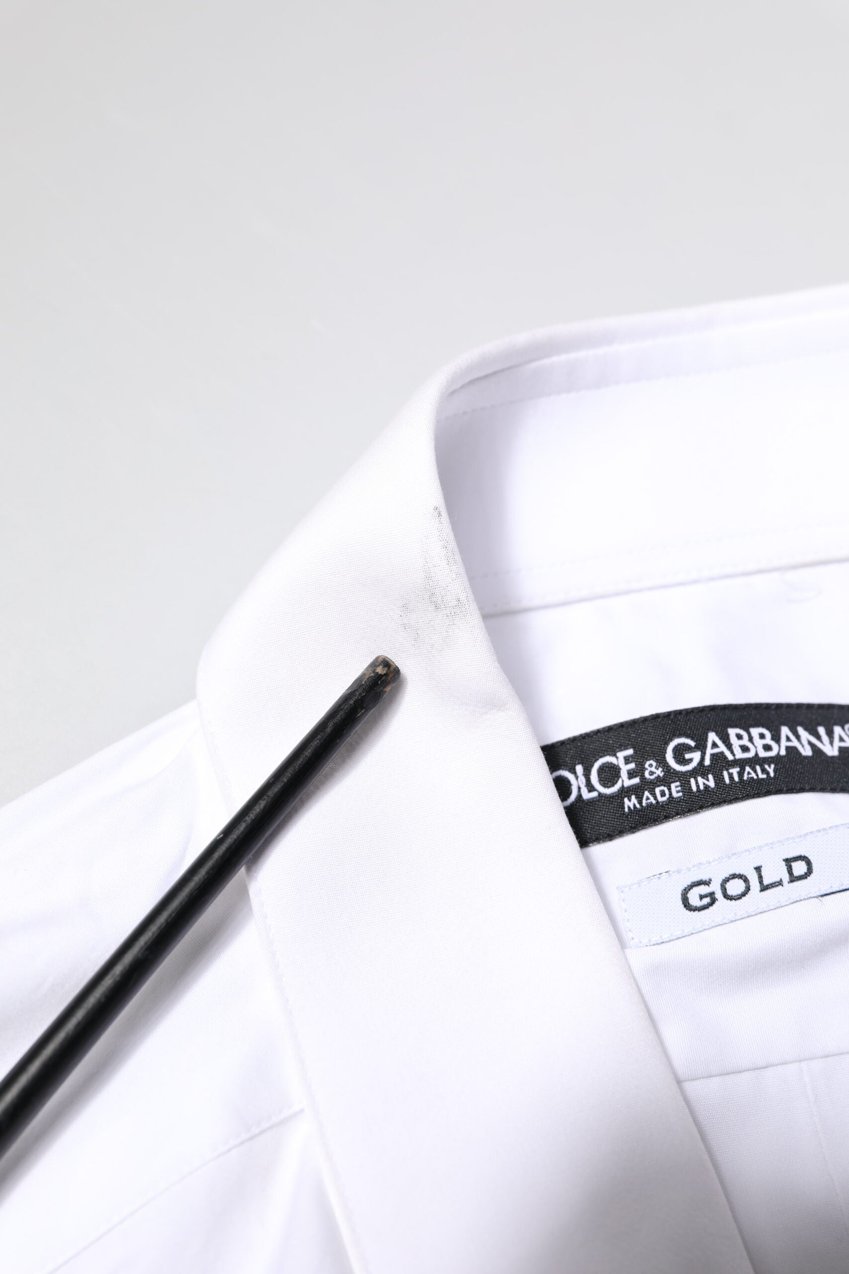 A white cotton dress shirt with gold accents from the brand Dolce & Gabbana