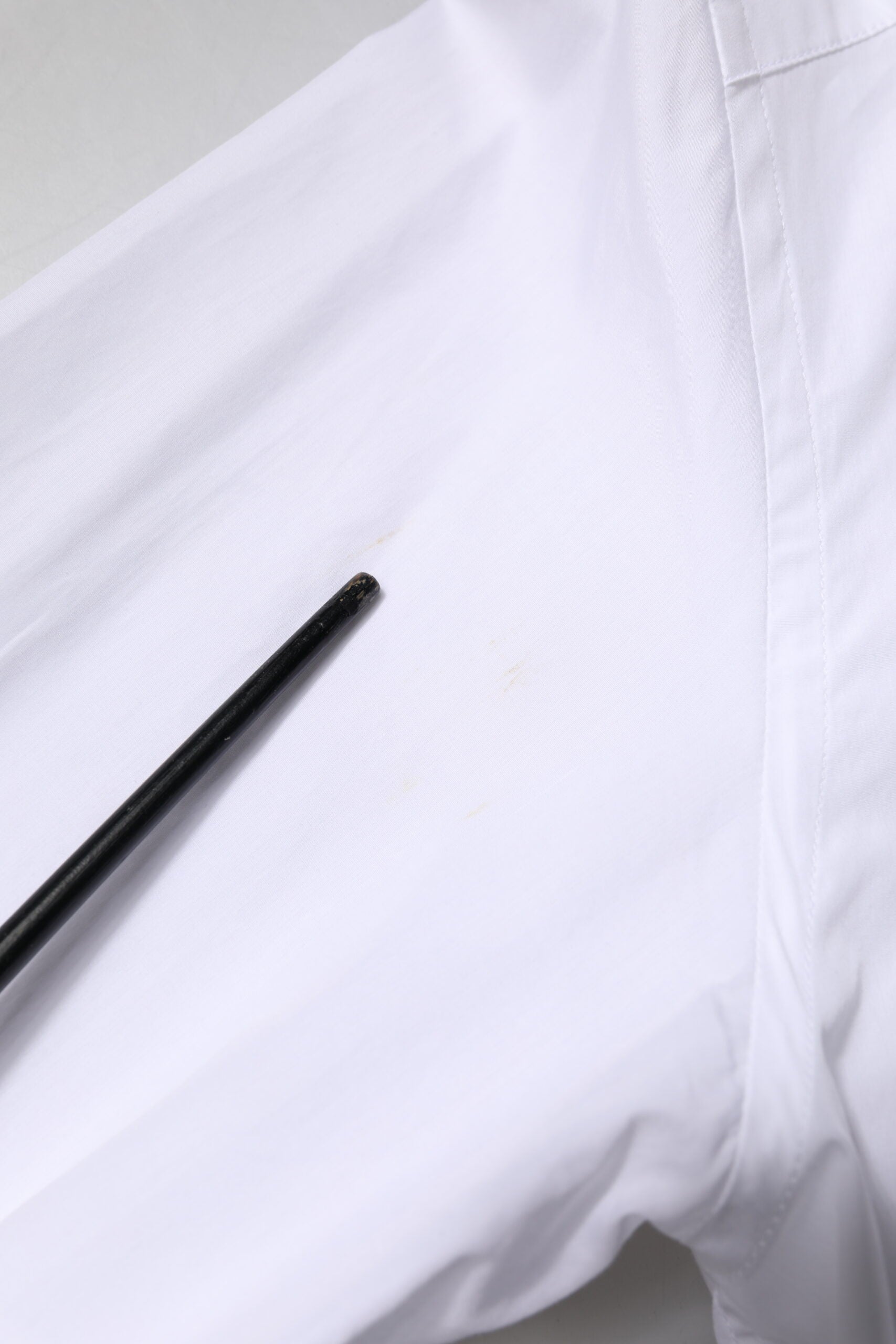 A white cotton poplin shirt with a gold bib detail, designed for formal men's wear