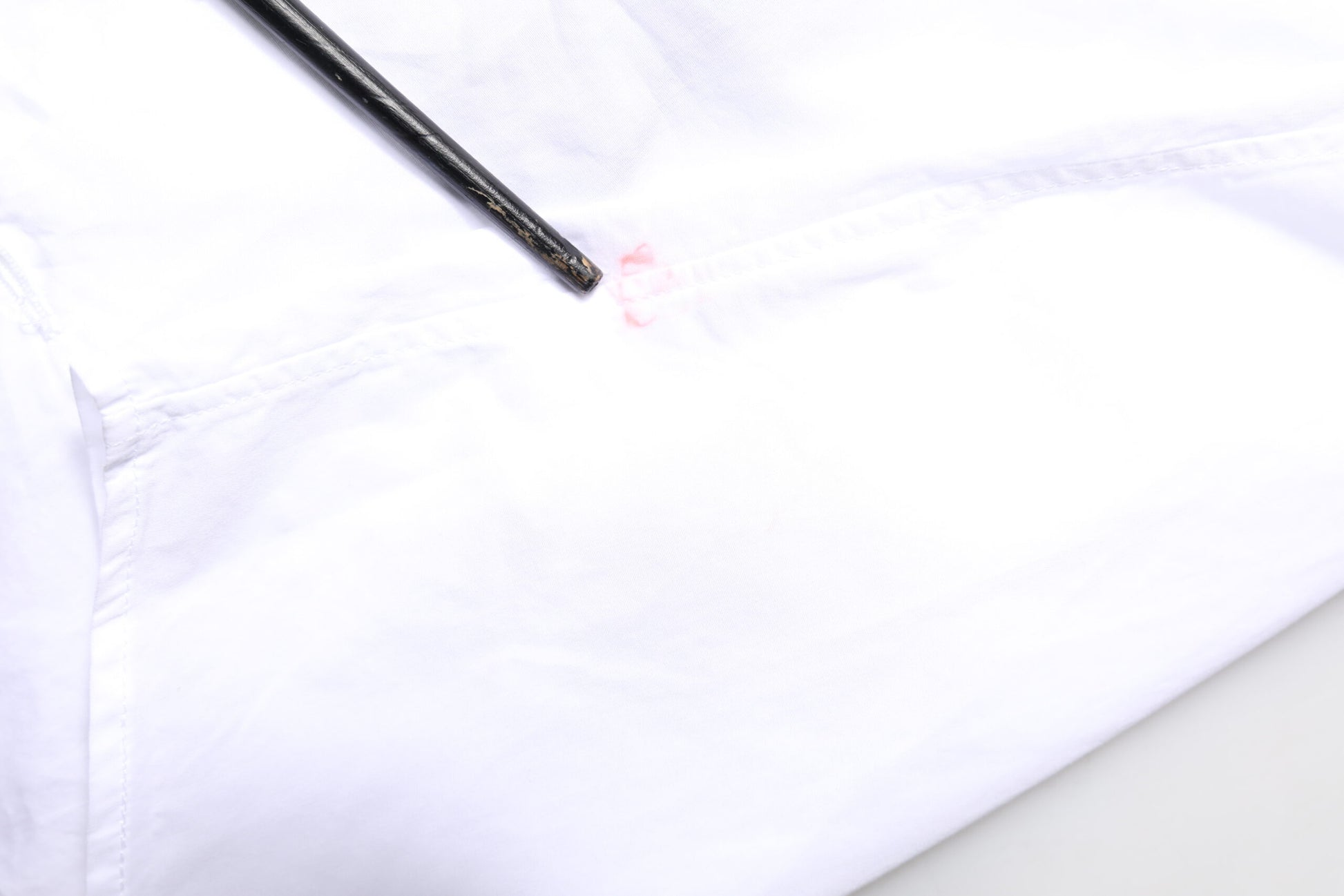 A white cotton poplin dress shirt with a gold bib and red stitching