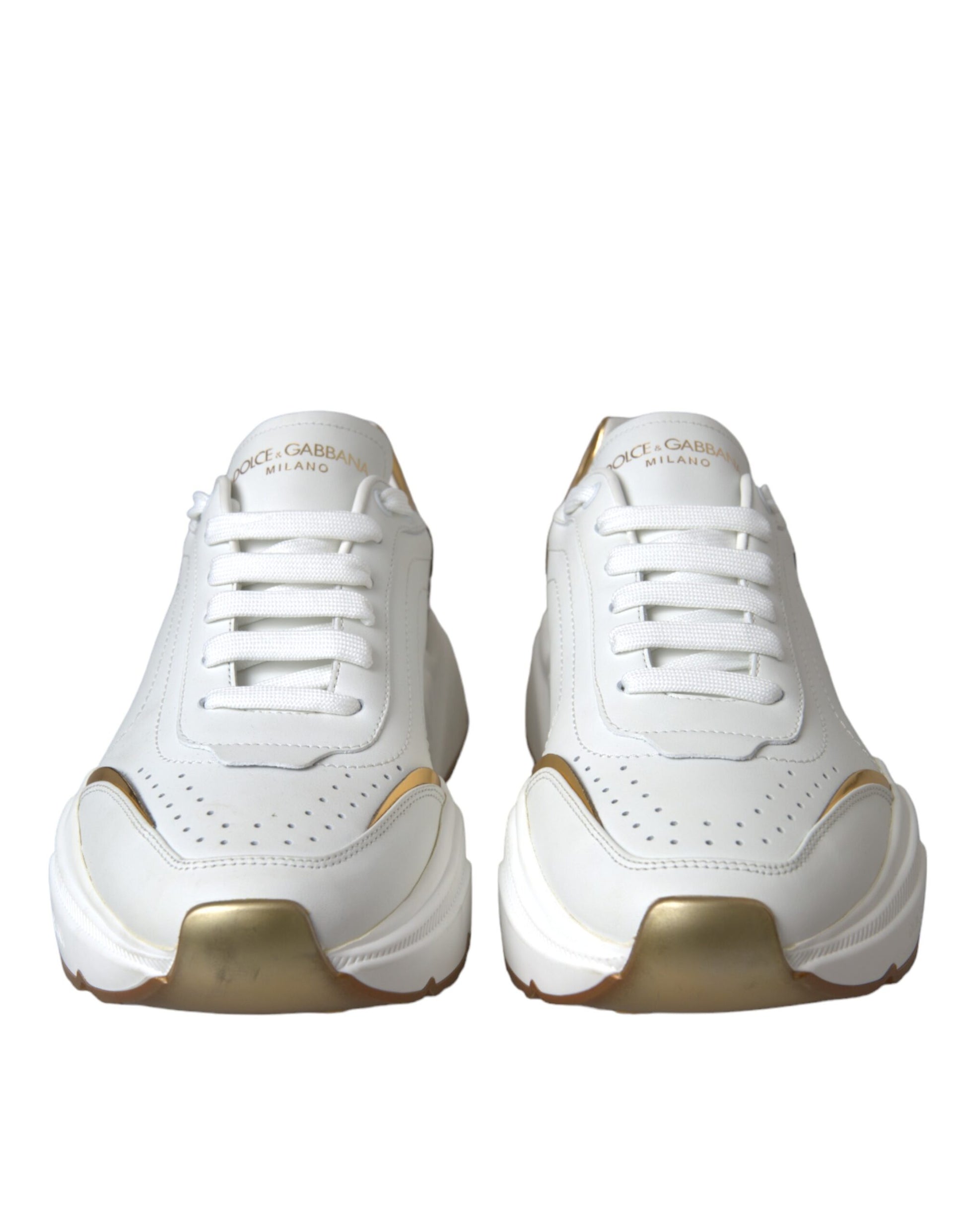 Pair of white sneakers with gold accents and laces