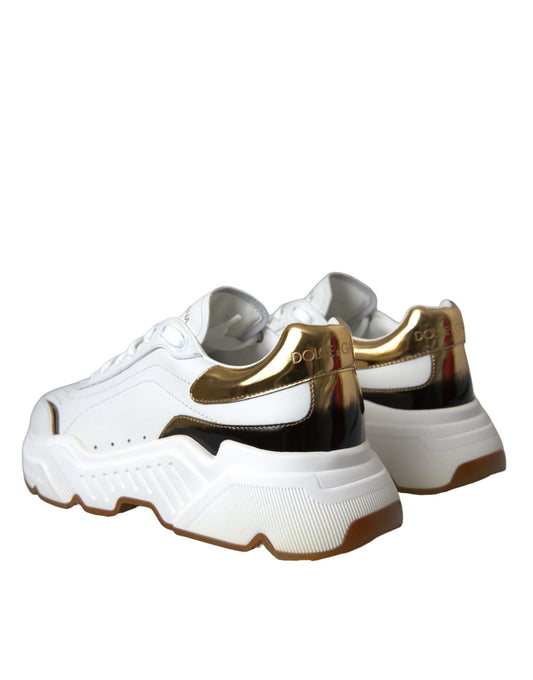 Pair of white sneakers with gold accents and black laces