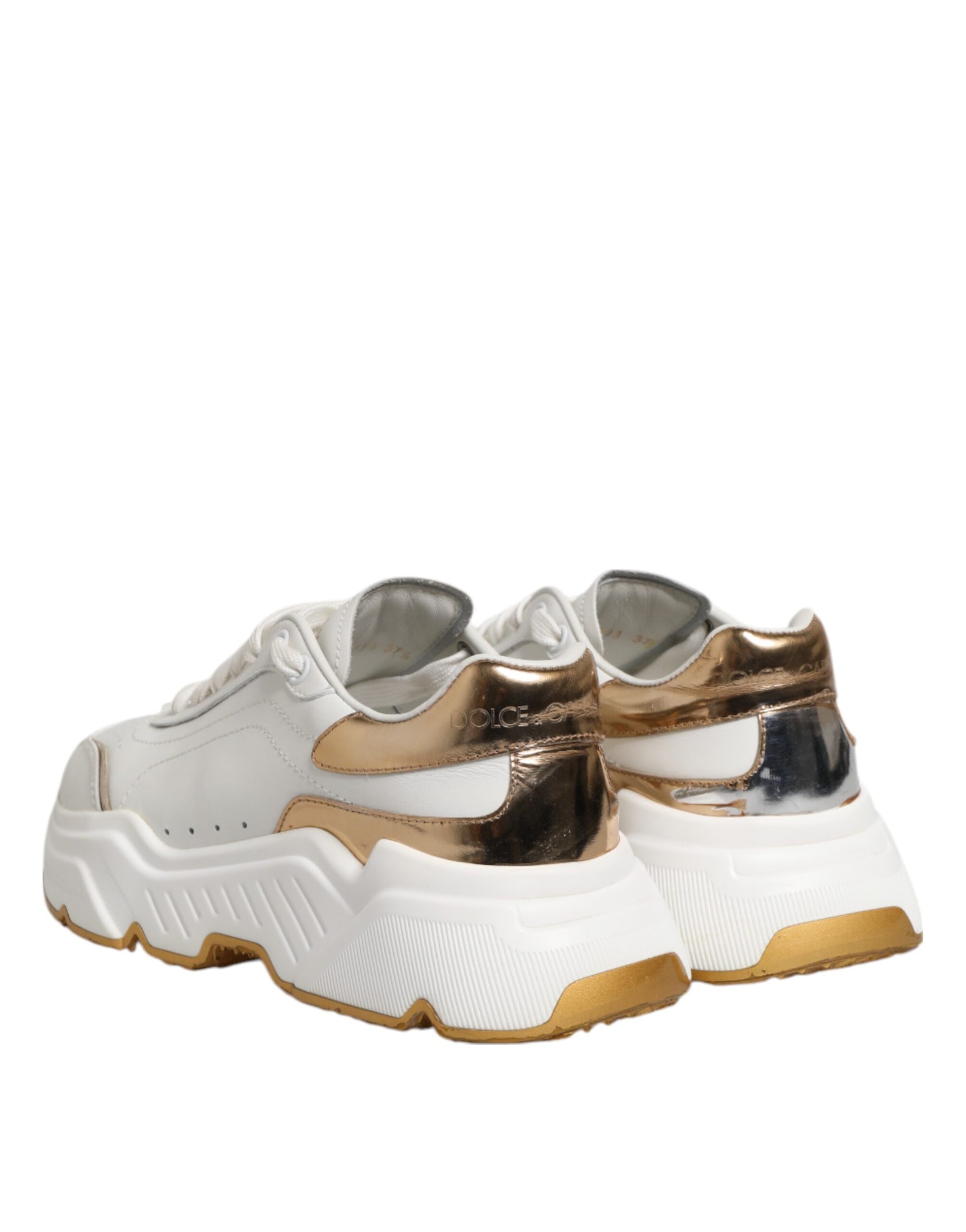 Pair of white gold leather sneakers with black soles, featuring a glittery texture and the brand logo