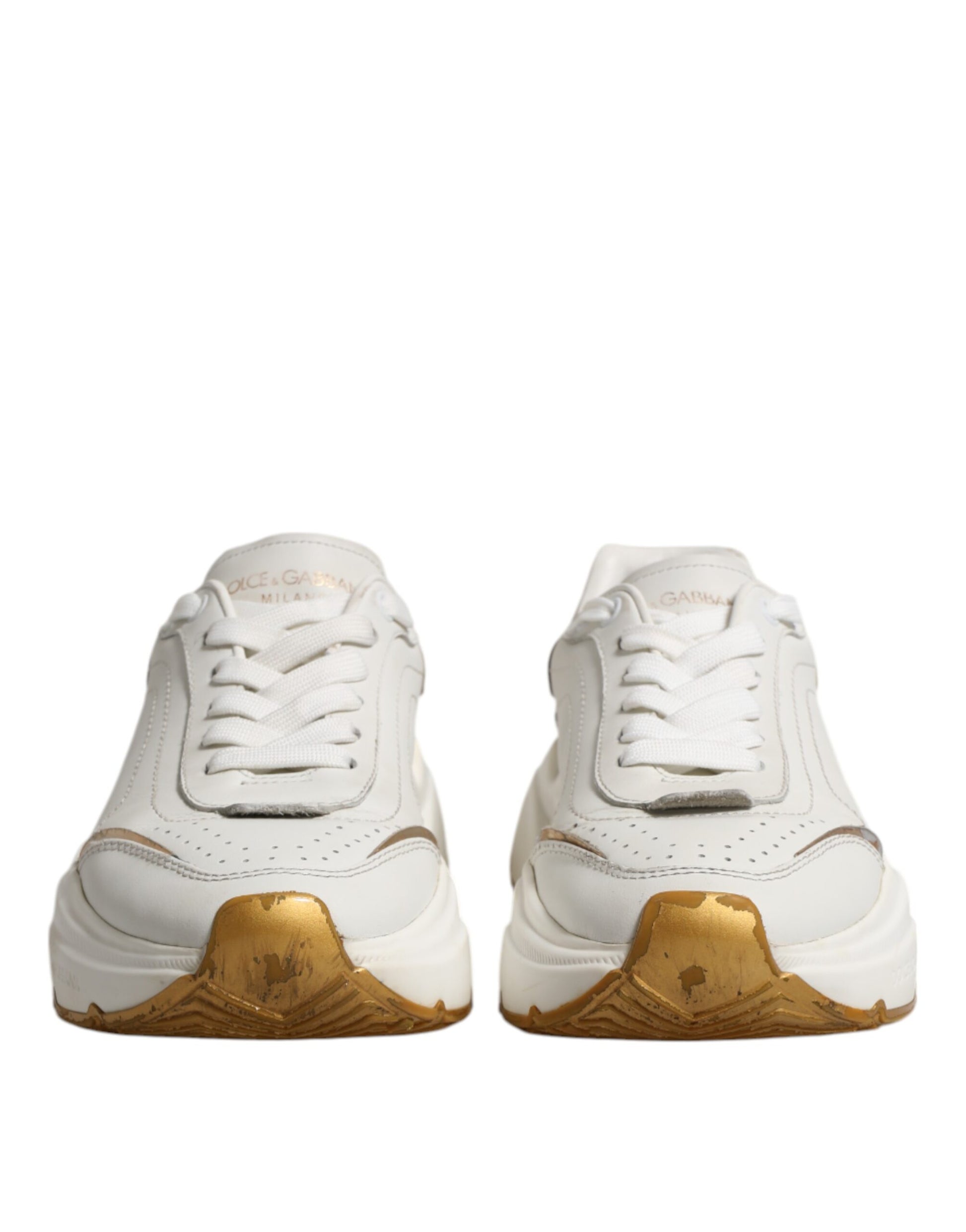 Pair of white gold sneakers with laces, branded logo on side and heel