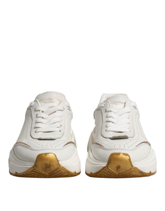 Pair of white gold sneakers with laces, branded logo on side and heel