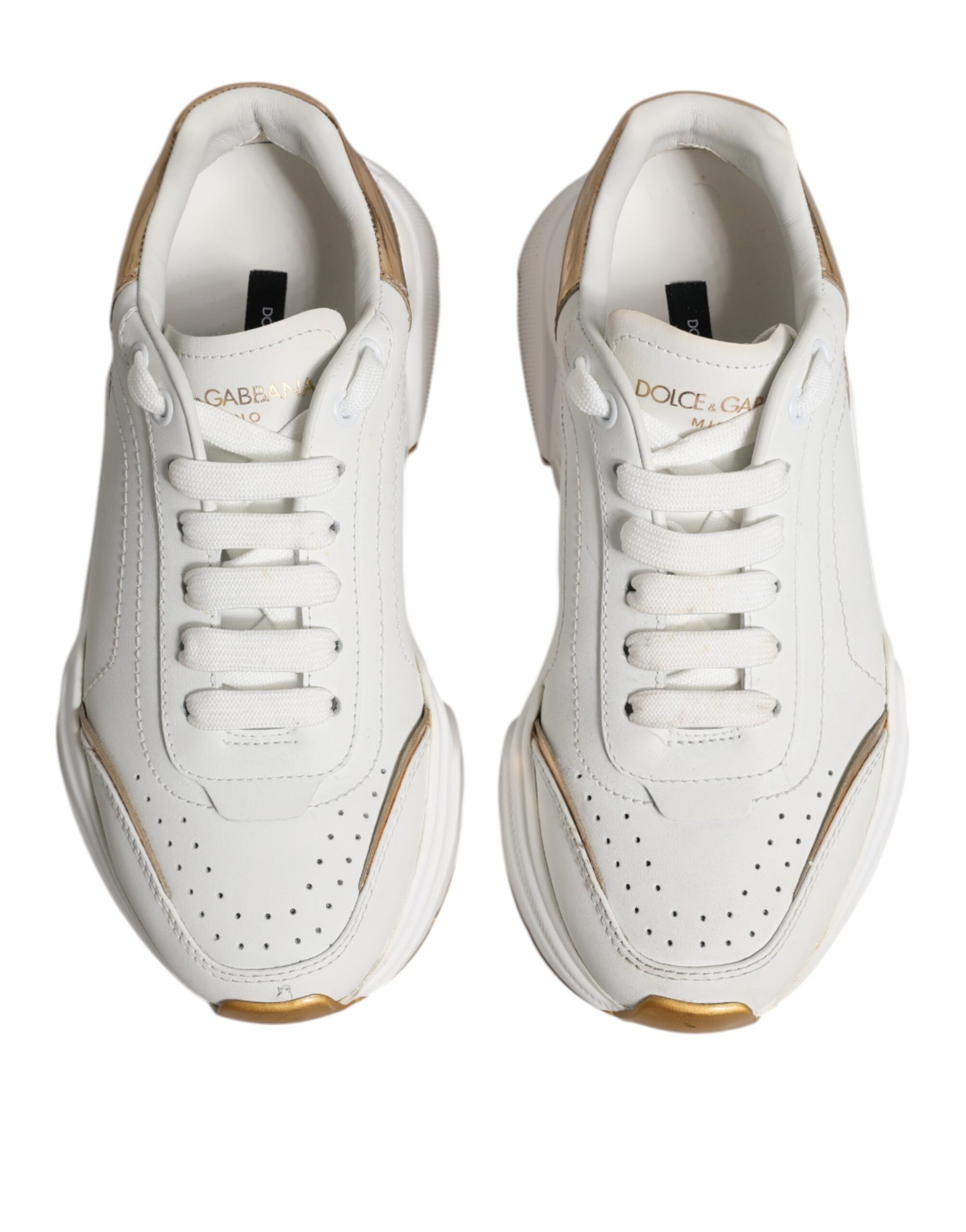 Pair of white gold D&G sneakers with laces, low top, and side stripe