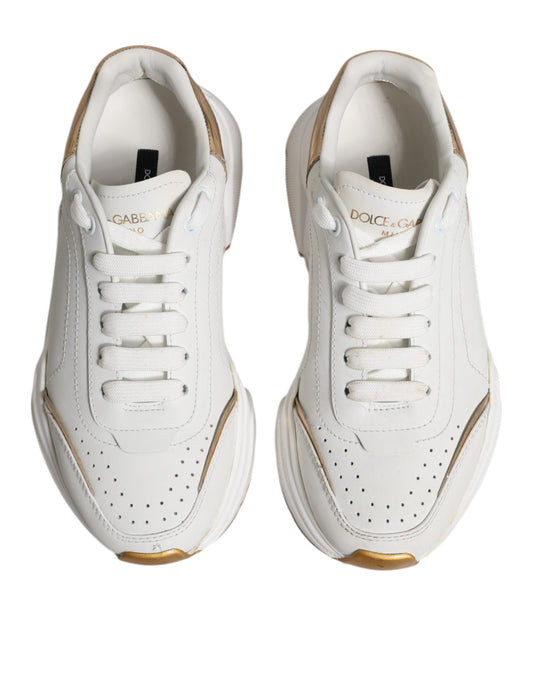 Pair of white gold D&G sneakers with laces, low top, and side stripe