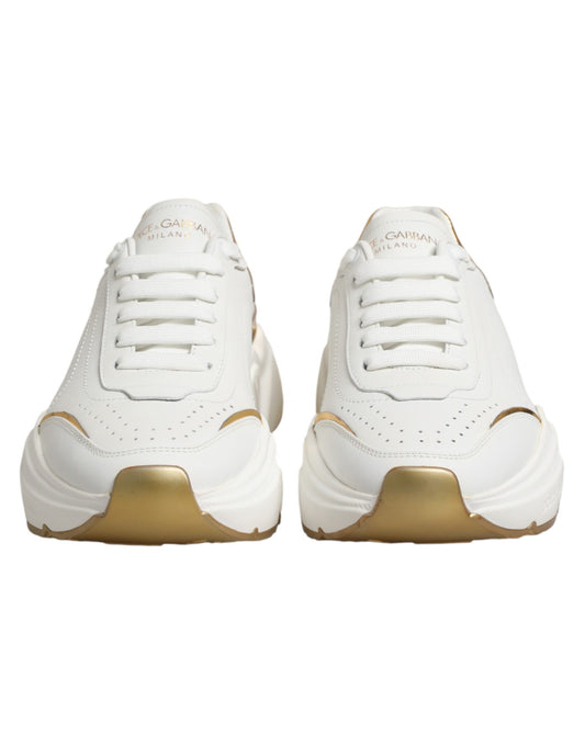 Pair of white gold sneakers with laces, featuring a low top and a logo on the side